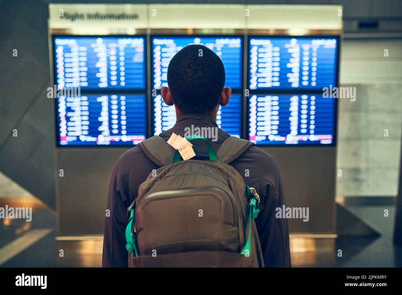 Welcher Flug gehört mir? Ein Mann, der die Flugzeiten auf einem Flughafen überprüft. Stockfoto