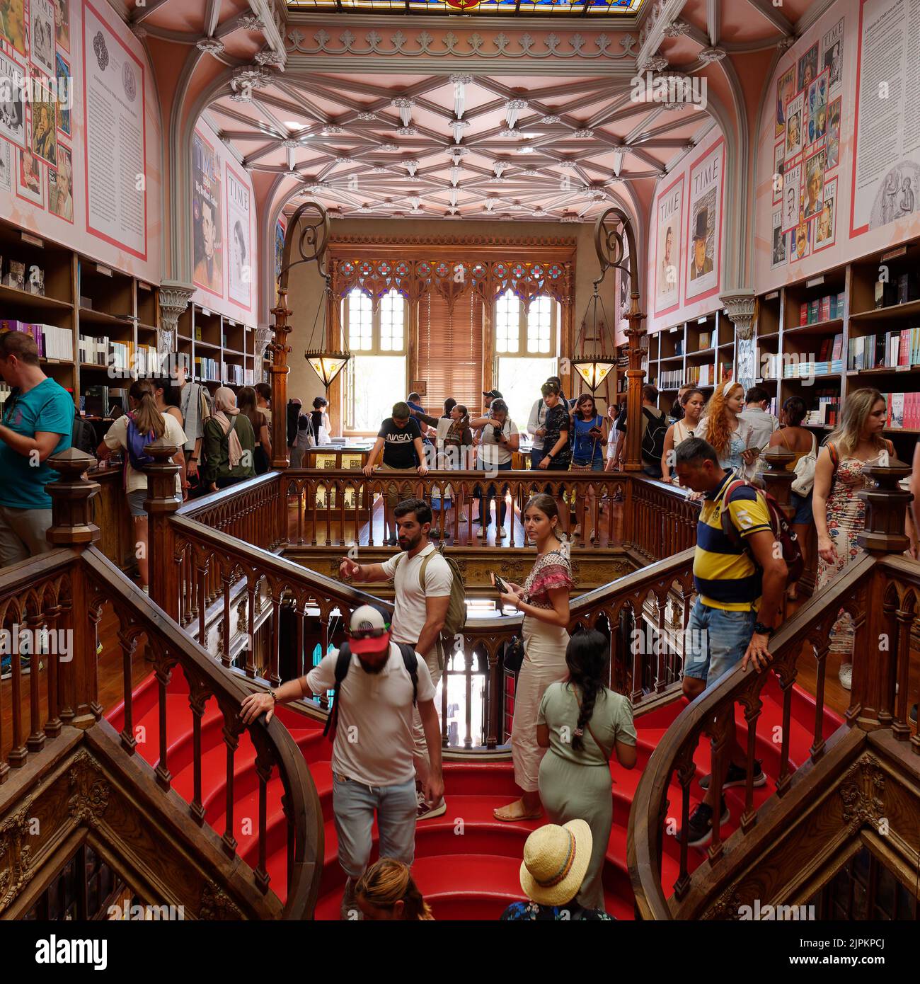 Interieur des schönen Livraria Lello aka Lello Buchhandlung in Porto, Portugal. Der Laden ist voll und die Leute steigen die berühmte rote Treppe hinunter. Stockfoto