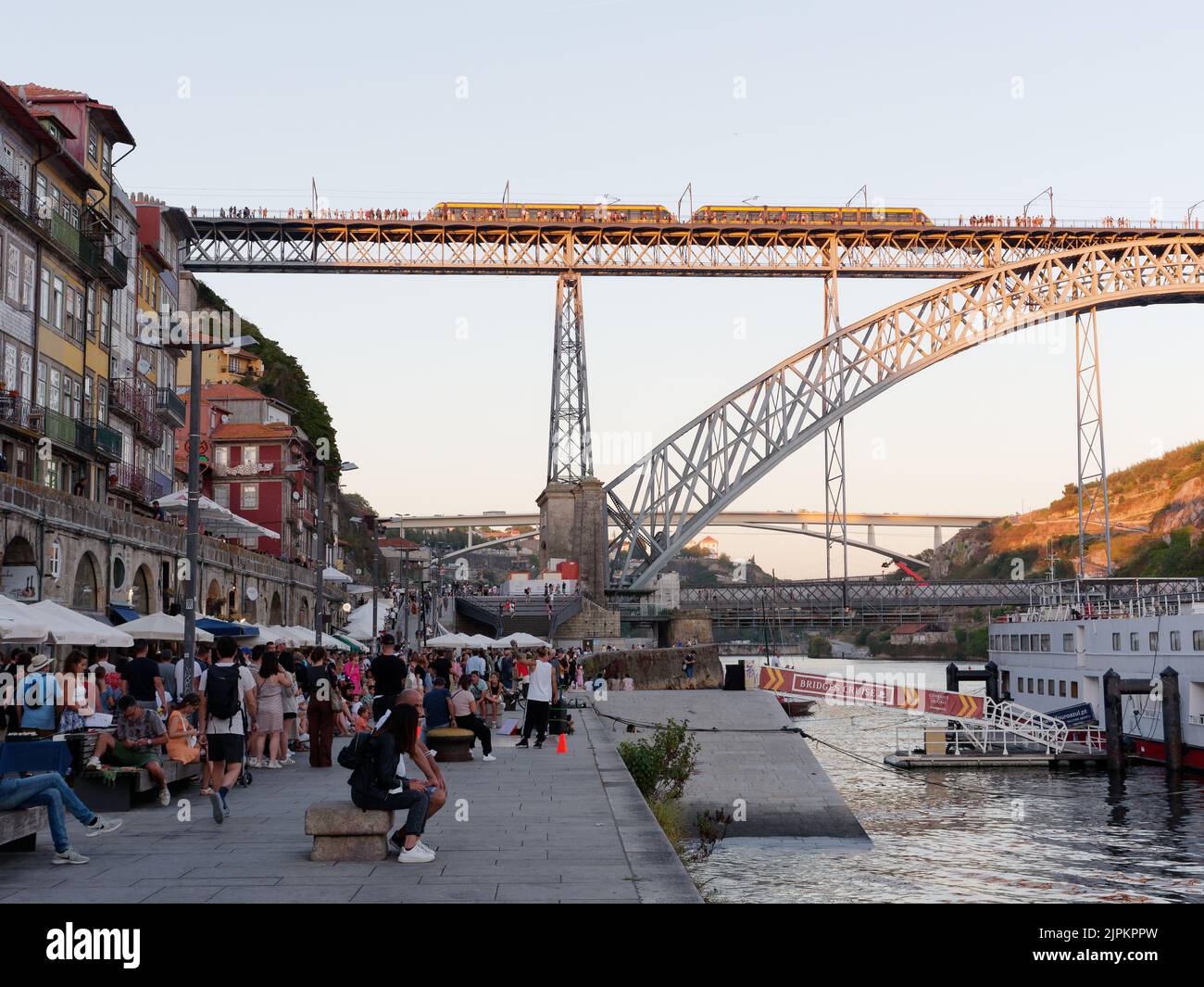 Marktstände im Ribeira aka Riverside Viertel von Porto, Portugal mit dem Duoro Fluss, Luis I Brücke mit Metro Zug. Stockfoto
