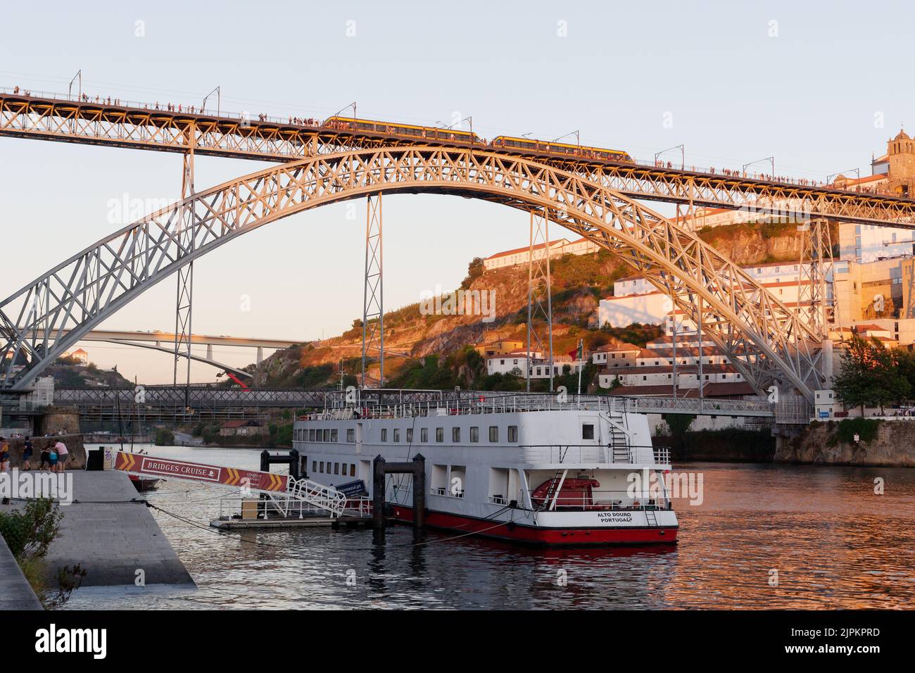 Boot auf dem Fluss Duoro in Porto mit Luis I Brücke und Vila Nova de Gaia an einem Sommerabend. Stockfoto
