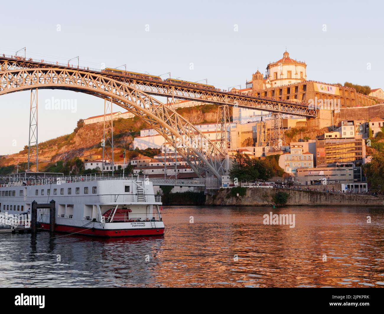 Boot auf dem Fluss Duoro in Porto mit der Luis I Brücke und Vila Nova de Gaia mit dem Kloster Serra do Pillar an einem Sommerabend. Stockfoto