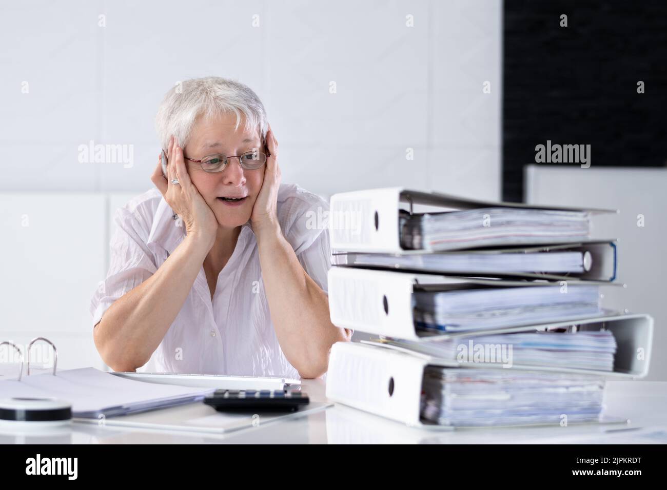 Unglückliche Frau Buchhalter mit Ordnern Arbeiten am Schreibtisch Stockfoto