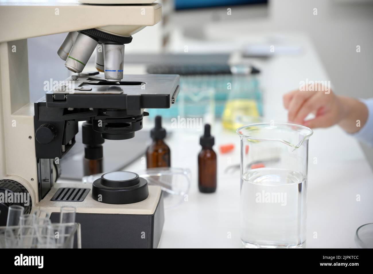 Wissenschaftler oder Chemiker Schreibtisch mit Mikroskop, konischem Becher, Tropfflasche, Reagenzgläsern und fortschrittlichen Geräten. Nahaufnahme Stockfoto