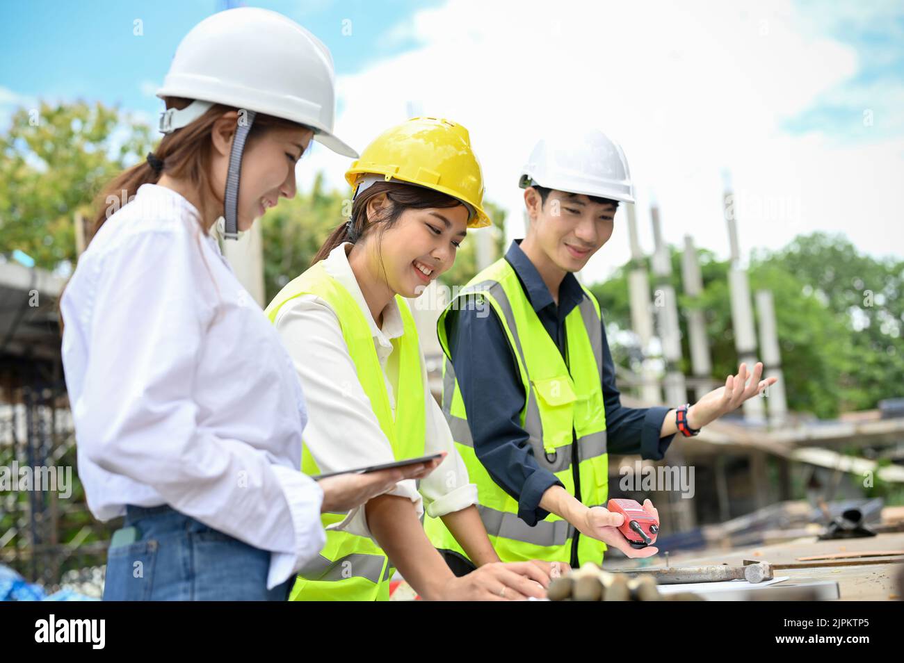 Eine wunderschöne asiatische Architektin, die sich im Freien mit ihrem Bauingenieur und Bauinspektor auf der Baustelle trifft. Zivile Triebwerke Stockfoto