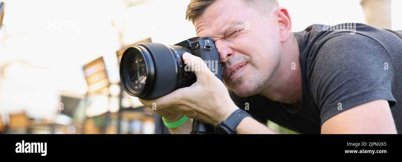 Der Fotograf macht Fotos mit einer modernen Kamera auf einem Stativ im Freien Stockfoto
