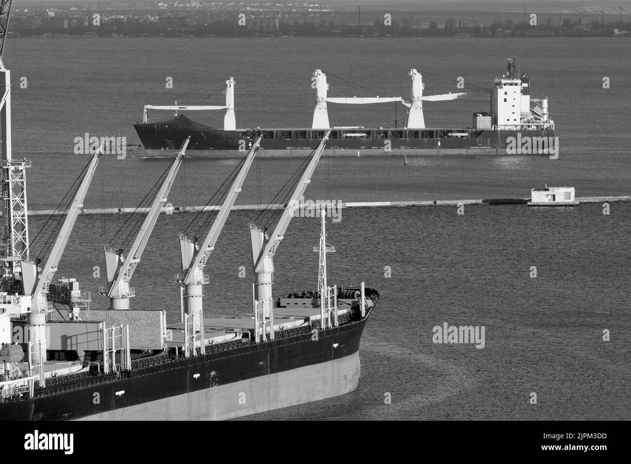 Kommerzieller Seehafen in Friedenszeiten. Schiffskräne, Lagerhäuser, Tanker, Fracht, Container und Schiffe im Seehafen Stockfoto