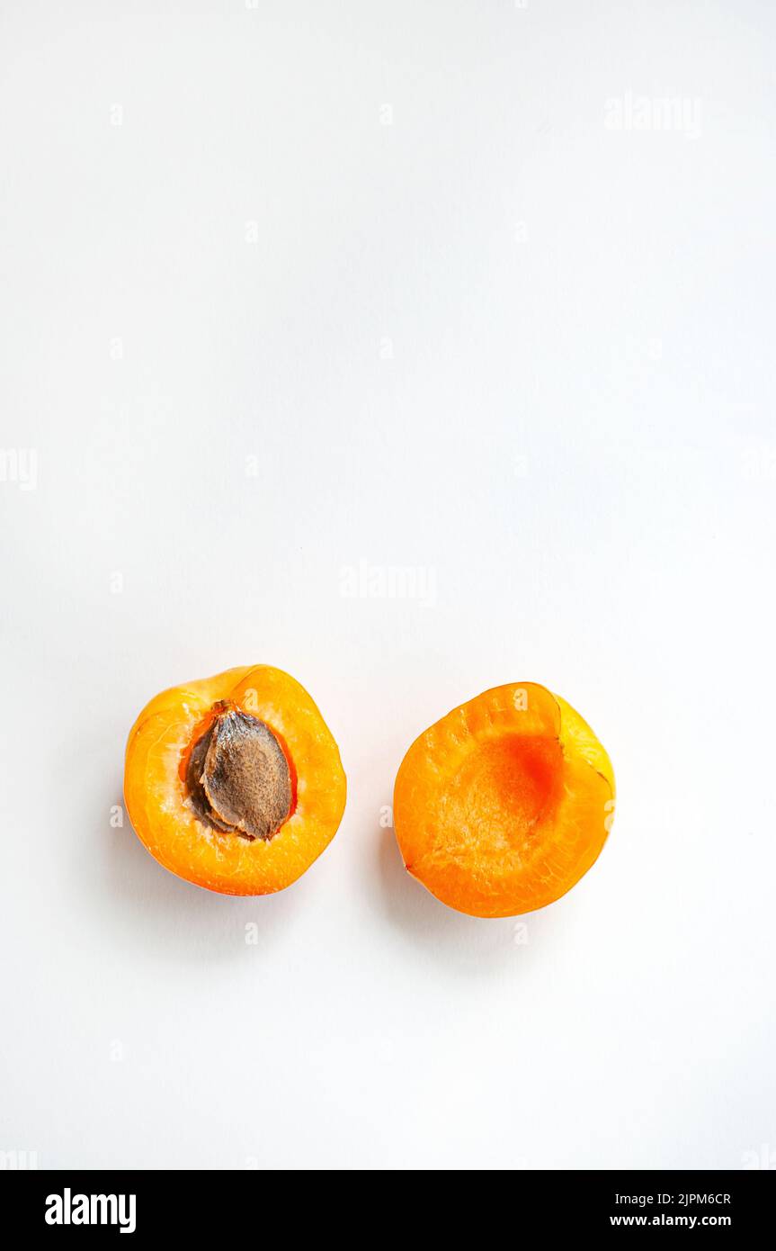 Eine reife, geschnittene Aprikose mit einem Samen auf weißem Hintergrund. Stockfoto