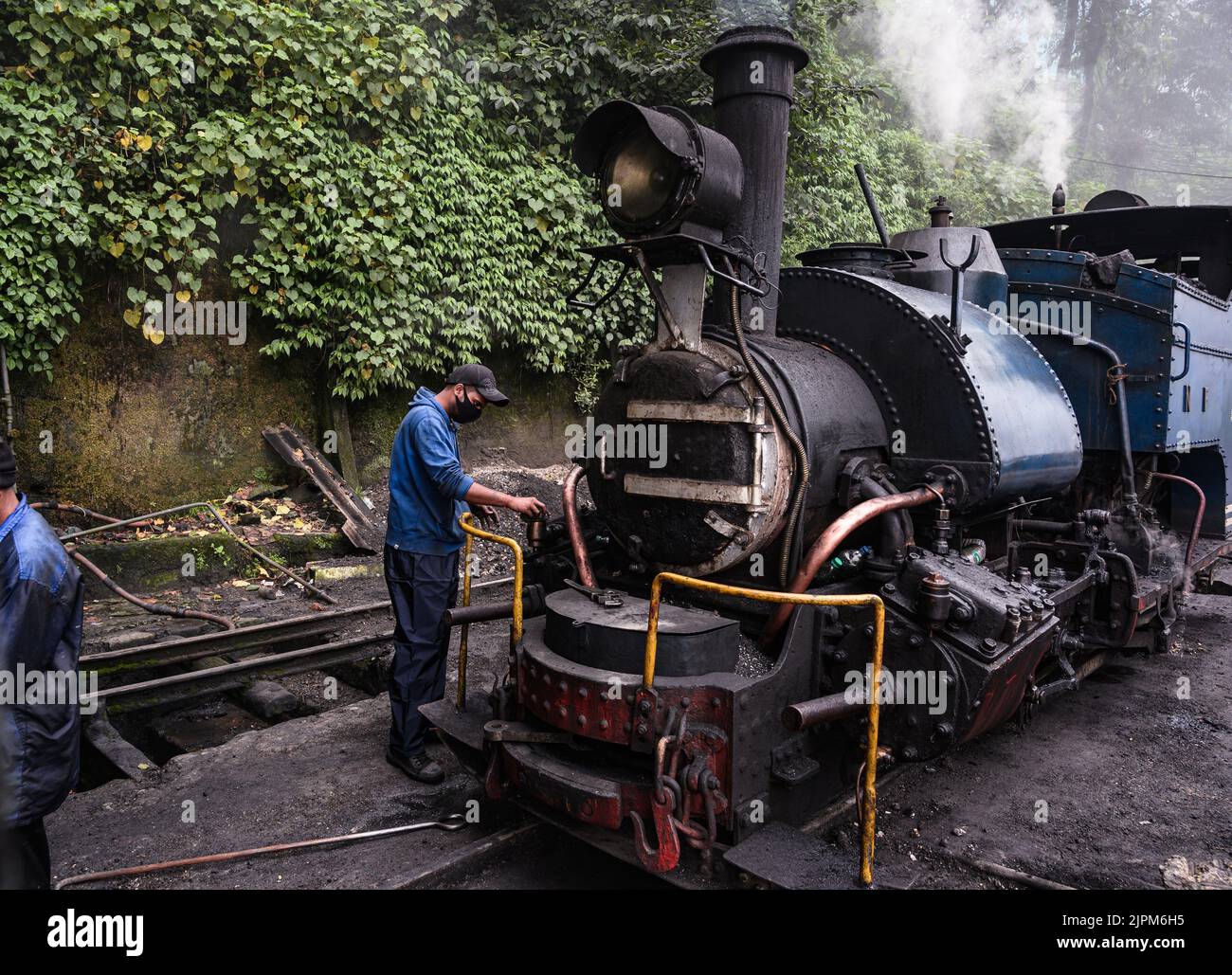 Die Darjeeling Himalayan Railway, ein UNESCO-Weltkulturerbe, auch bekannt als DHR oder Toy Train, ist eine 610-mm-Eisenbahnstrecke, die zwischen New Jalpaiguri und Darjeeling im indischen Bundesstaat Westbengalen verkehrt. Er klettert von etwa 100 m über dem Meeresspiegel bei New Jalpaiguri auf etwa 2.200 m (7.200 ft) bei Darjeeling, wobei er sechs Zickzack und fünf Schleifen verwendet, um Höhe zu gewinnen. Sechs Diesellokomotiven übernehmen den größten Teil des Liniendienstes, darunter tägliche Touristenzüge von Darjeeling nach Ghum – Indiens höchster Bahnhof – und der dampfgetrabene Red Panda-Dienst von Darjeeling nach Kurseong. Stockfoto