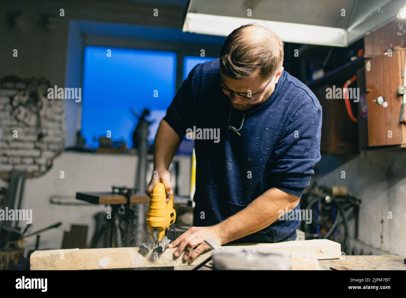 Zimmermann sägt Holz mit einer elektrischen Stichsäge. Stockfoto