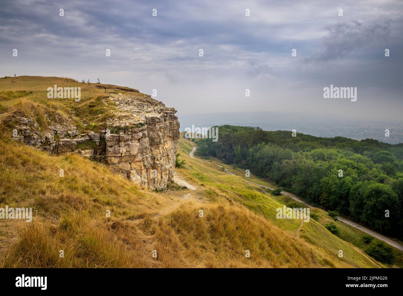Castle Rock auf dem Cotswold Way in Cleeve Hill mit Blick auf das nebelbedeckte Cheltenham Spa, Gloucestershire, England Stockfoto