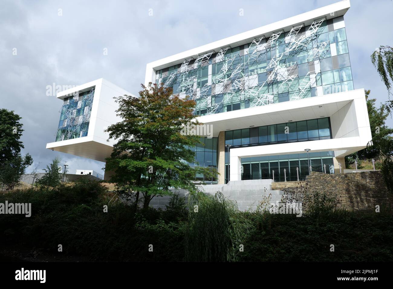 Weißes Kastengebäude mit Leitermuster über der Glasfront Stockfoto