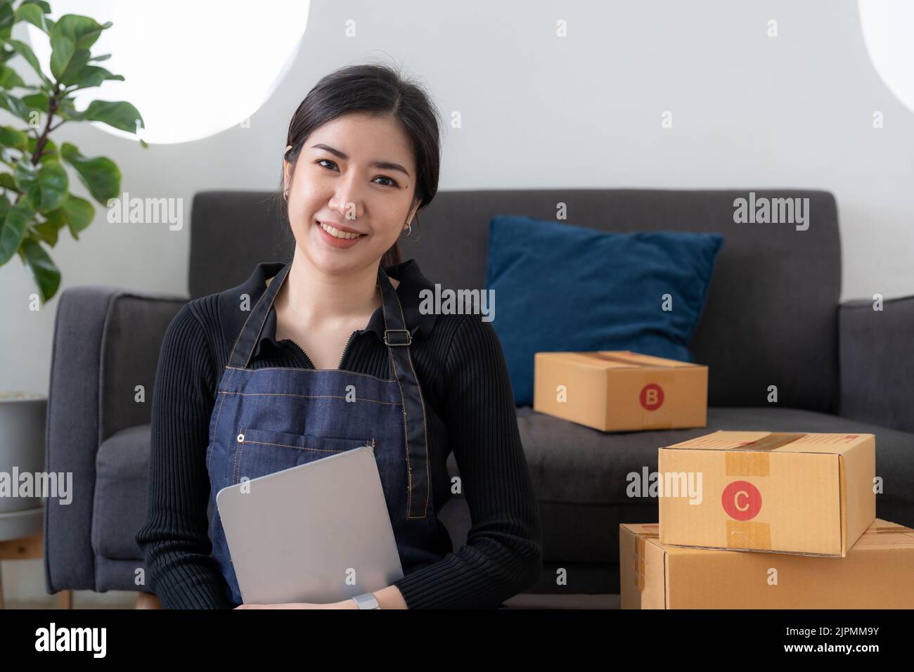 Portrait asiatische Geschäftseigentümer Frau bereiten Paket-Box und überprüfen Online-Bestellungen des Produkts für die Lieferung an den Kunden auf Laptop-Computer. Online Einkaufen Stockfoto