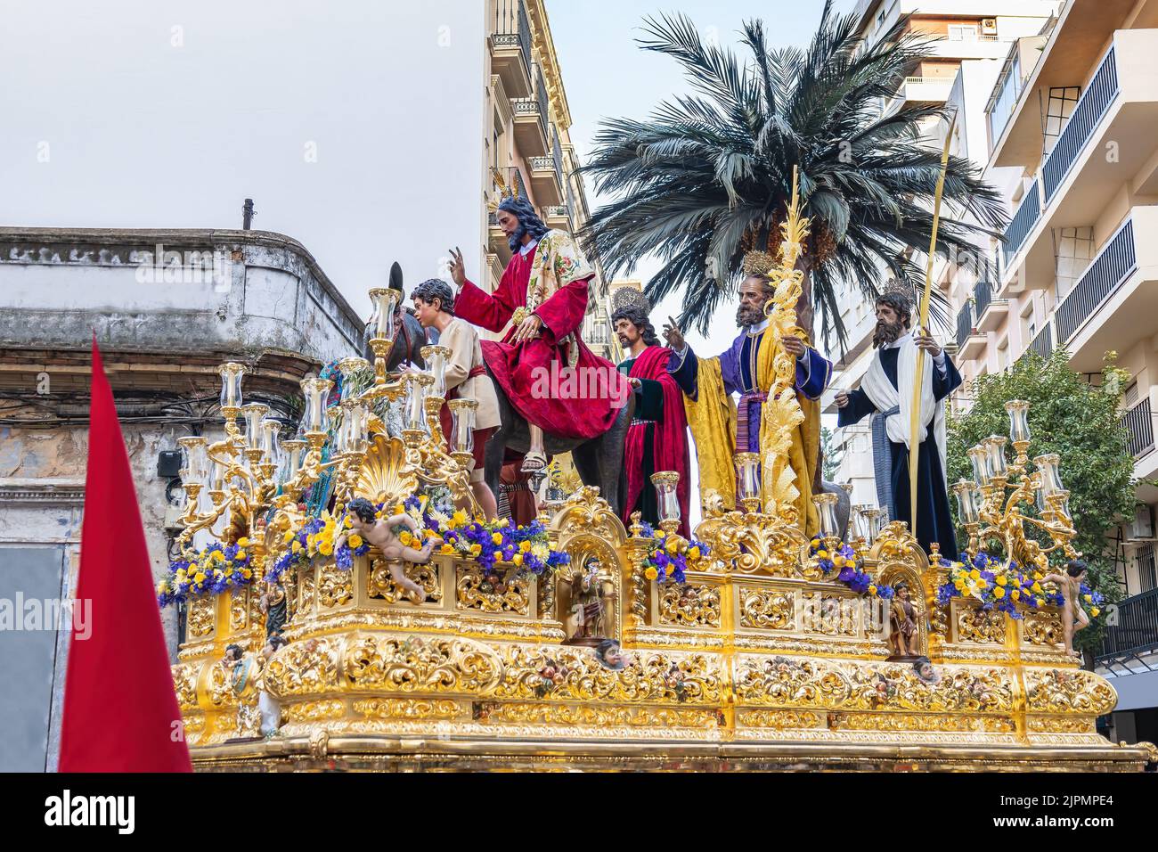 Christus reitet auf einem Esel auf dem Thron oder der Plattform der Bruderschaft der La Borriquita, in einer Prozession durch die engen Gassen der Stadt Stockfoto