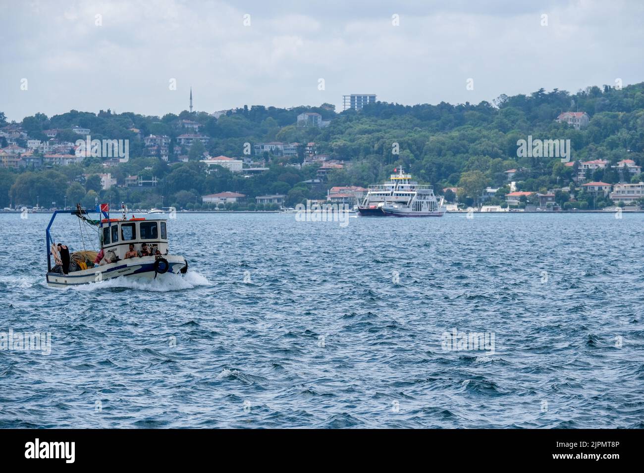 Istanbul, Türkei. 10. August 2022. Ein Fischerboot vor einer CityLine Fähre in Bosporus. Während der Wind von Lodos im Bosporus weht, segeln und fischen Fischerboote. Wenn zu diesem Zeitpunkt internationale Schiffe den Bosporus passieren, kommt es zu starkem Verkehr. (Bild: © Aufnahmen von TOZ/SOPA über ZUMA Press Wire) Stockfoto