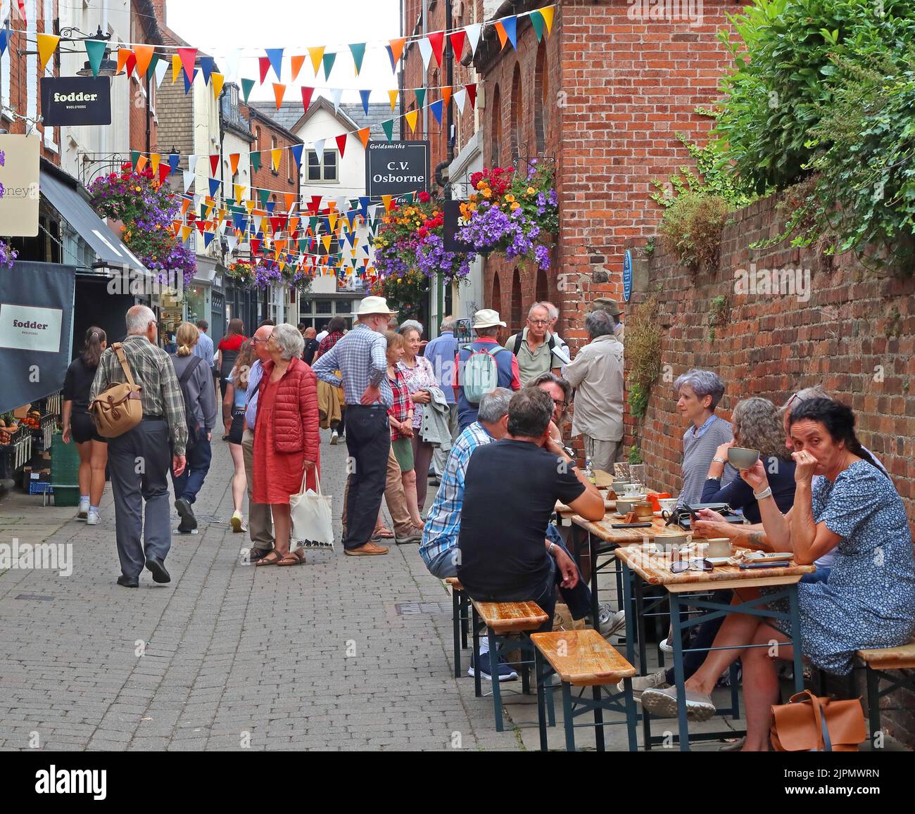 Kirchenstraßenbesucher und Touristen in der engen historischen Altstadt von Herefords, Essen unter freiem Himmel an Straßentischen, Herefordshire, England, Großbritannien, HR1 2LR Stockfoto