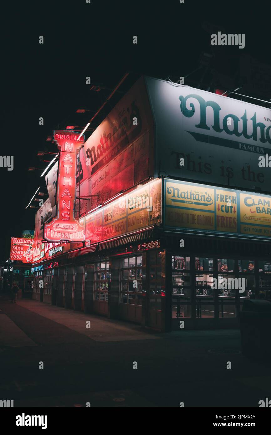 Eine schöne Aufnahme von Nathan's berühmtem Fast-Food-Restaurant am Abend Stockfoto