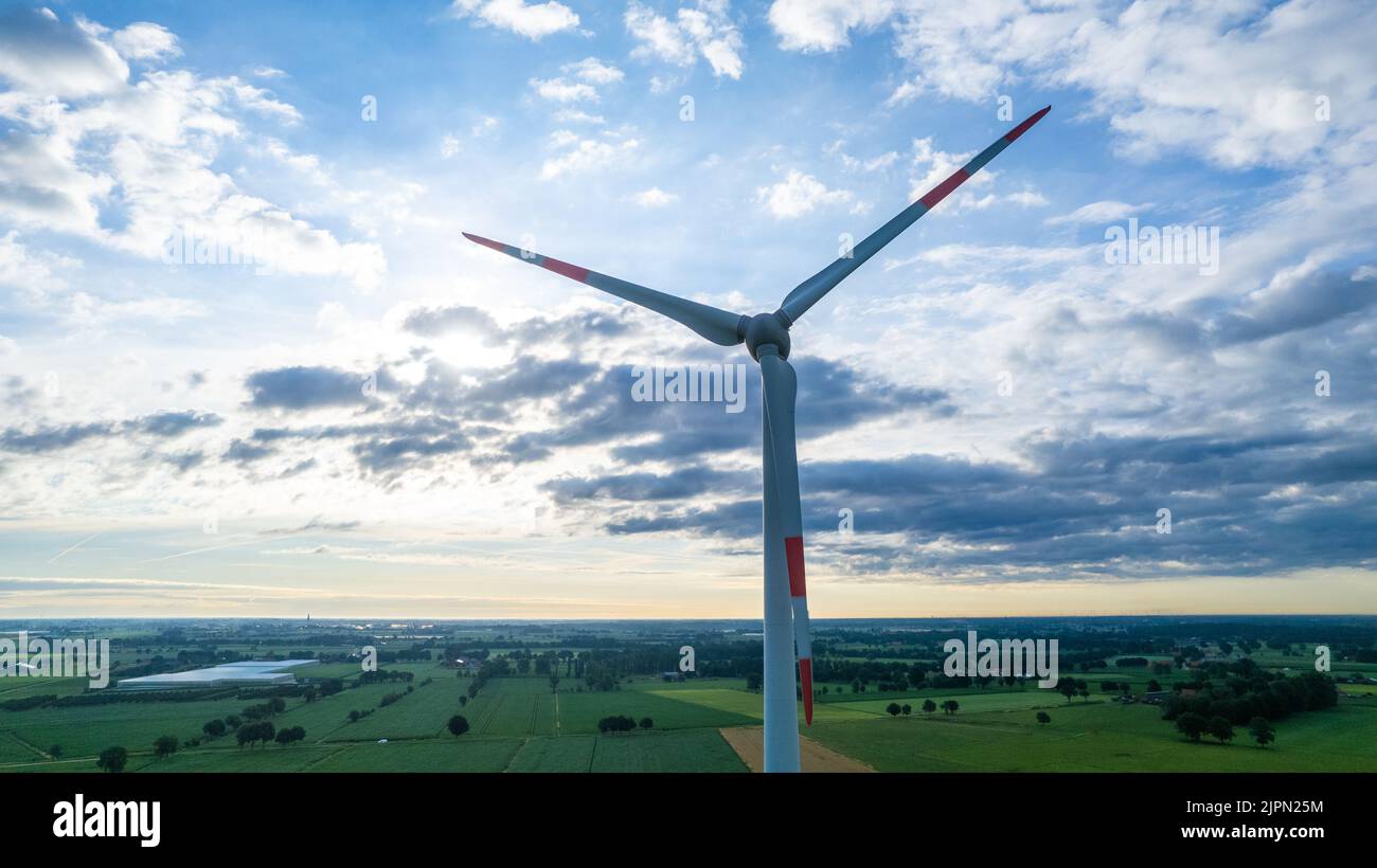 Windmühle für die elektrische Energieerzeugung, alternative Energie, in einer ländlichen Gegend während des Sonnenuntergangs. Hochwertige Fotos Stockfoto