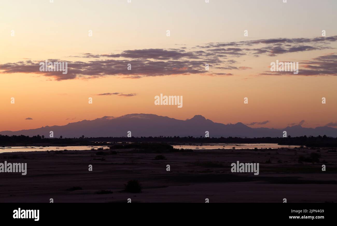 Blick vom Rufiji River Camp aus flussaufwärts an einem klaren Abend sind die Uluguru Mountains im späten Licht deutlich umrissen. Stockfoto