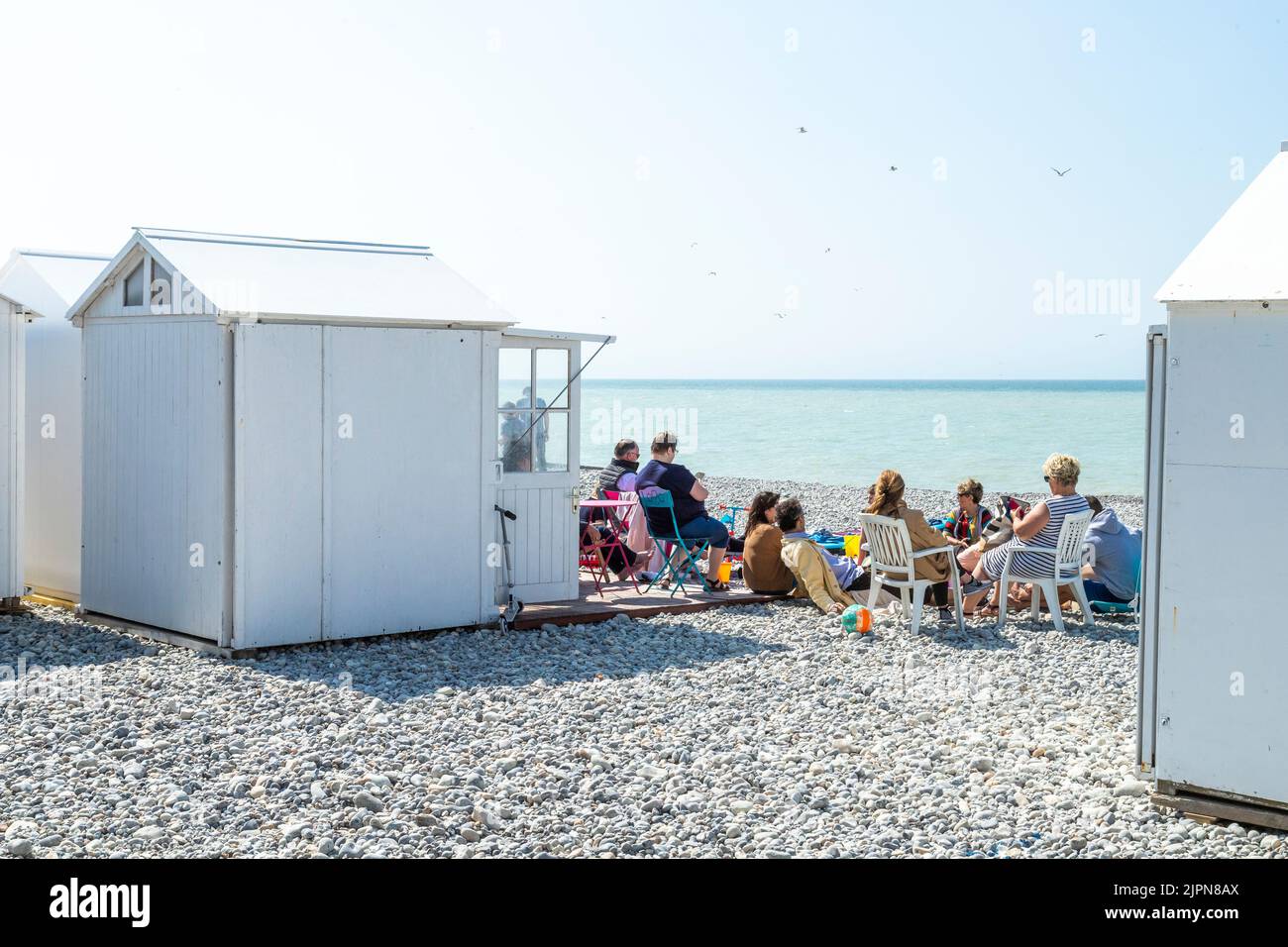 Frankreich, Somme, Picardie, Mers les Bains, Strand mit einer Gruppe von Leuten, die vor einer Strandhütte sitzen // Frankreich, Somme (80), Picardie, Mers les Bain Stockfoto