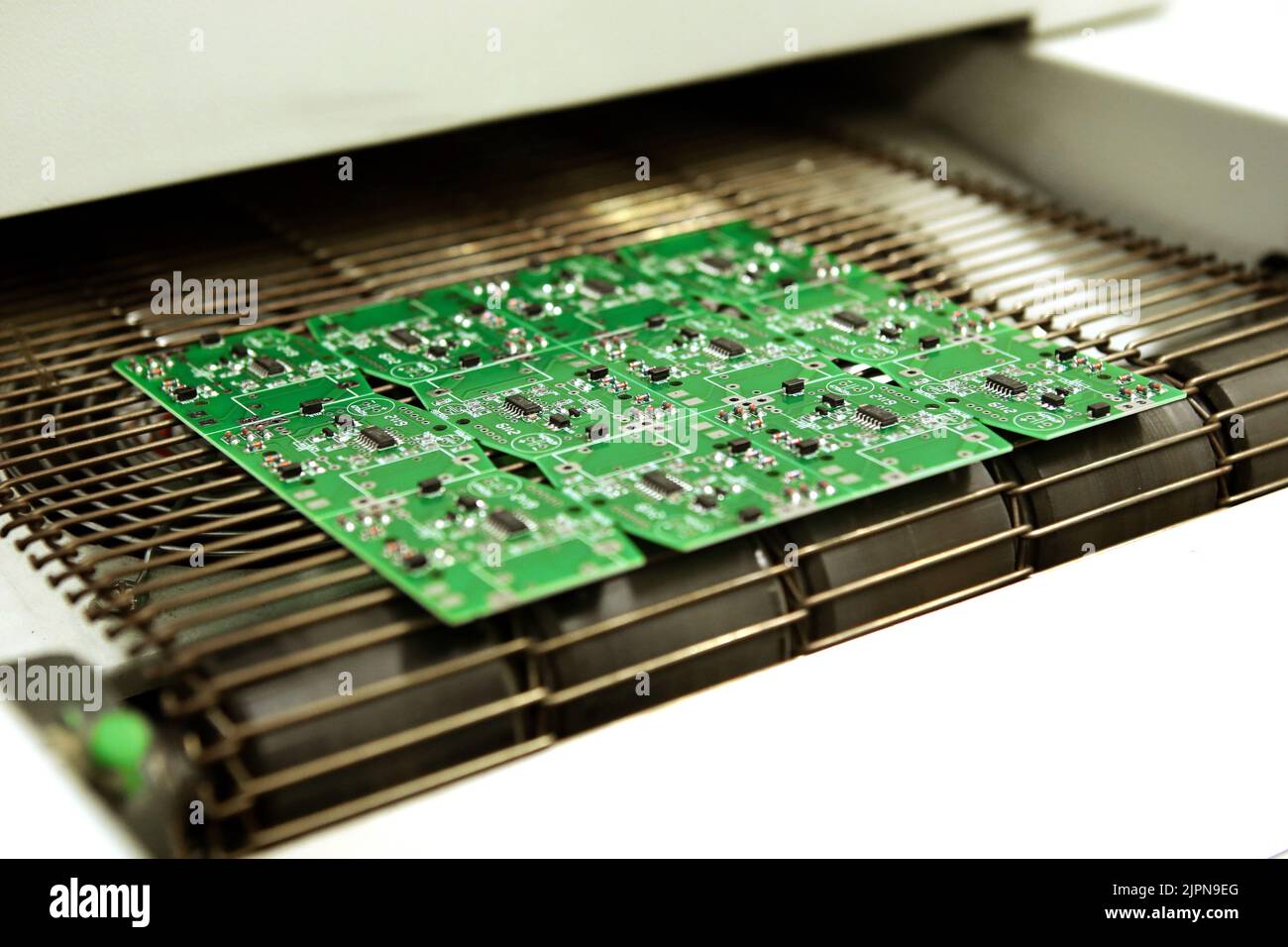 PCB-Trocknungstechnologie. Das fertige Brett verlässt den Trockenofen entlang des Förderers. Stockfoto