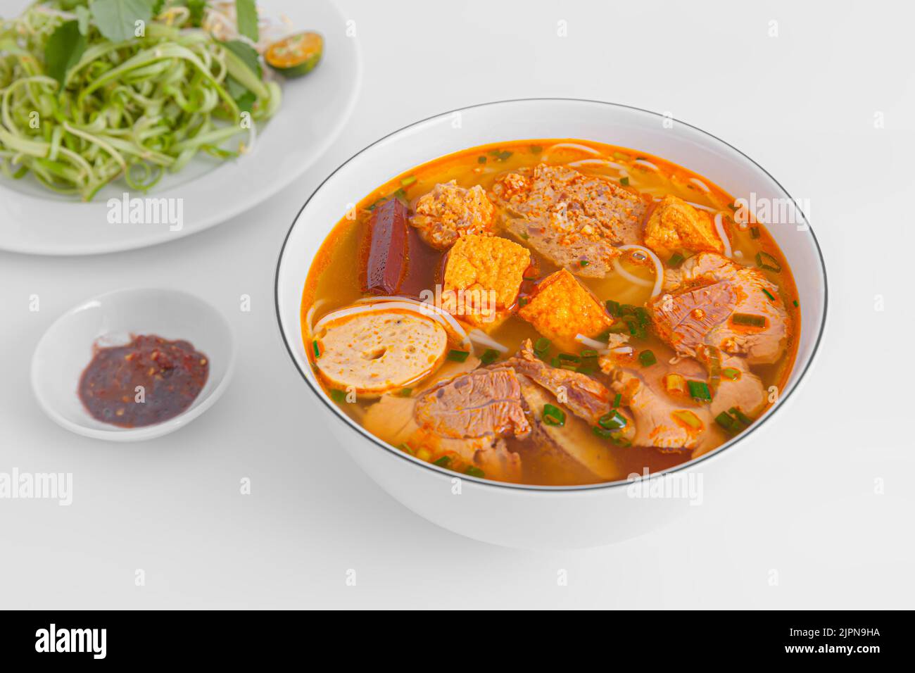 Bun Rieu Cua, Krabbenpaste Vermicelli-Suppe mit gehackten Garnelen, Tofu, Tomaten, Garnelenpaste, vietnamesisches Essen auf weißem Hintergrund isoliert, Nahaufnahme Stockfoto