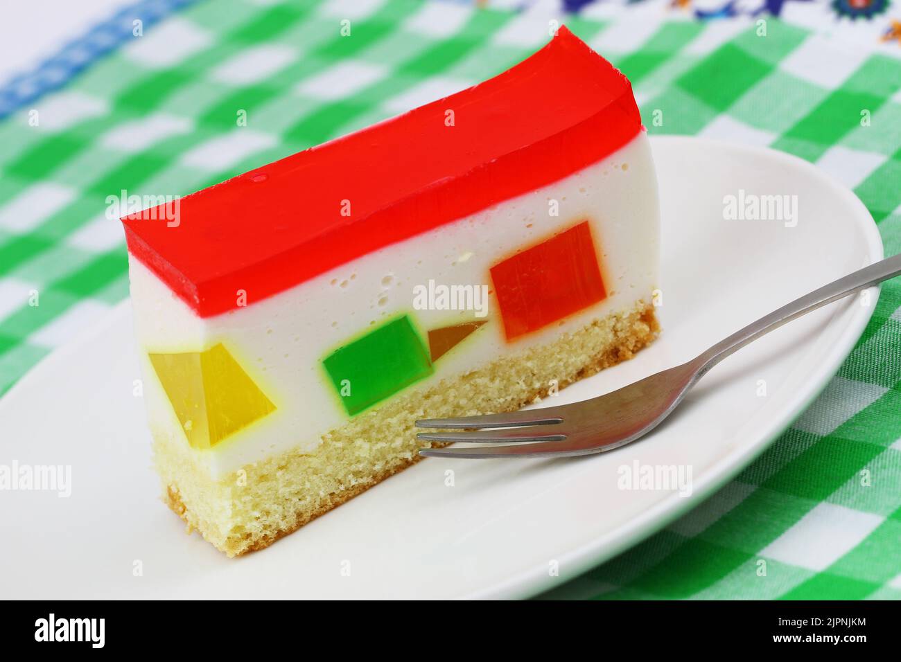 Käsekuchen mit bunten Stücken von Fruchtgelee, Nahaufnahme Stockfoto