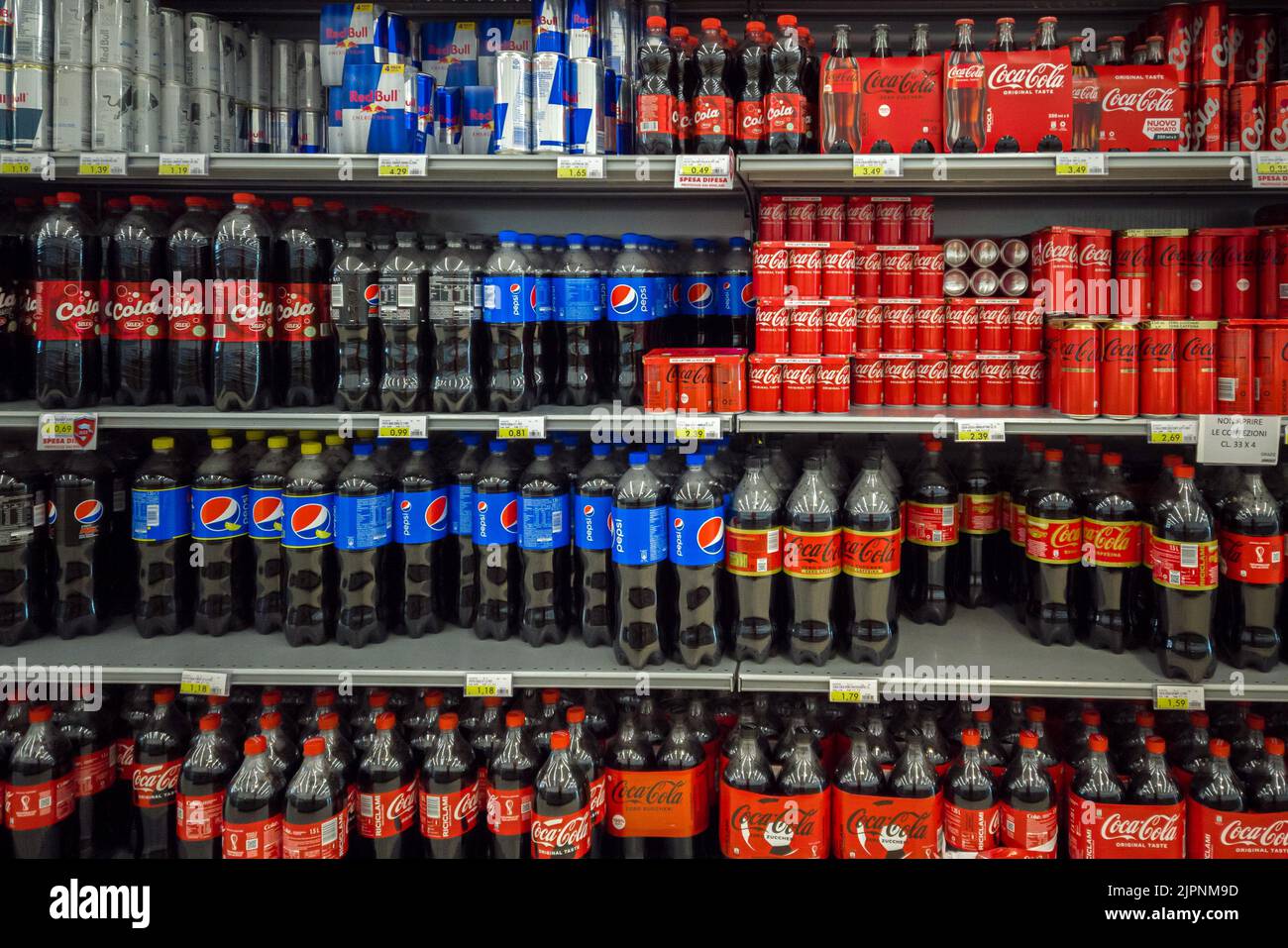 Fossano, Italien - 19. August 2022: Italienisches Supermarktregal, das Flaschen und Dosen von Coca Cola, Pepsi und Red Bull verkauft Stockfoto