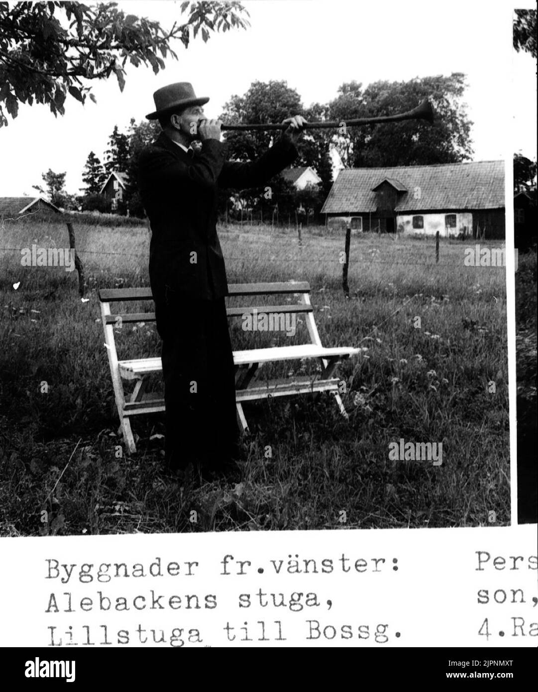 Elderlyman f.d. Bauern Erik Darius spielt Lur. Abbildung 2. Gebäude von links: Alebacken's Hütte, Lillstuga bis Bossgården. Alte Bossg.s Scheune gerissen. Ålderman f.d. lantbrukare Erik Darius spelar lur. Bild 2. Byggnader från Vänster: Alebackens stuga, lillstuga till Bossgården. Gamle Bossg.s ladugård riven. Stockfoto