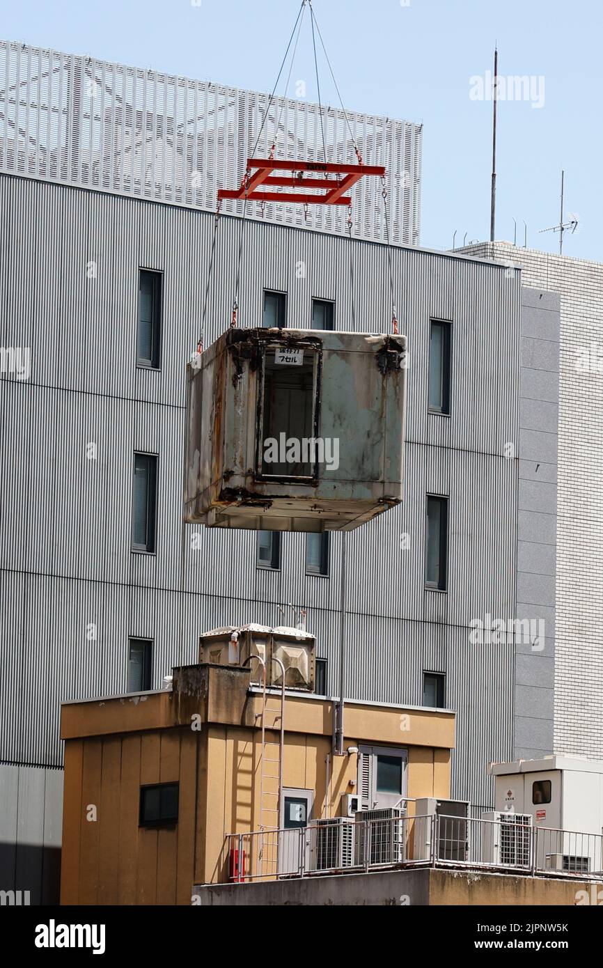 Tokio, Japan. 19. August 2022. Ein Kran trägt eine Kapsel während des Abrisses am Nakagin Capsule Tower in Ginza am 19. August 2022 in Tokio, Japan. Der Rückbau von 140 Einzelkapseln des futuristischen Gebäudes (Mischnutzung Wohn- und Büroturm) wird im Rahmen der Abbrucharbeiten bis Ende dieses Jahres fortgesetzt. Quelle: Rodrigo Reyes Marin/AFLO/Alamy Live News Stockfoto