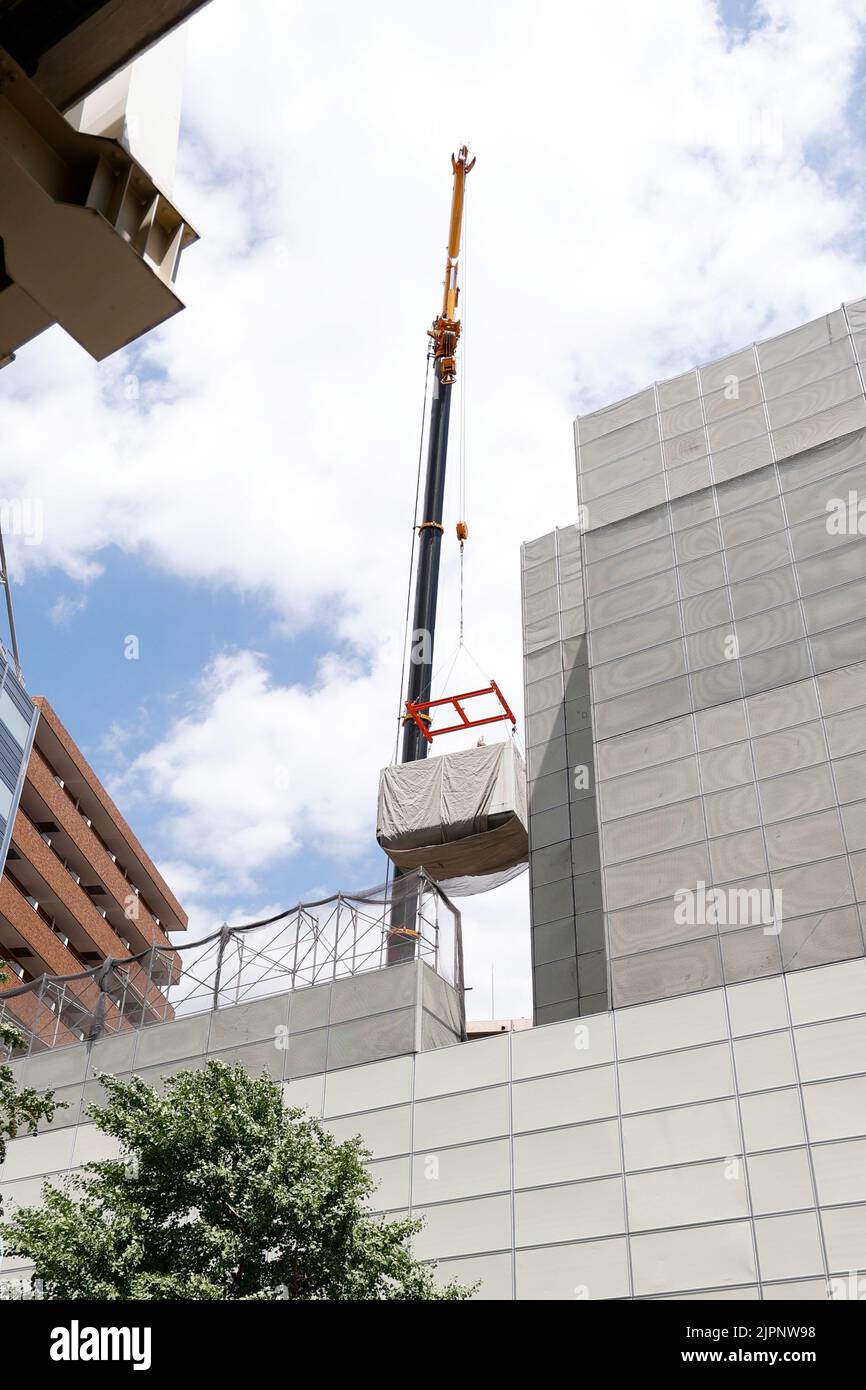 Tokio, Japan. 19. August 2022. Ein Kran trägt eine Kapsel während des Abrisses am Nakagin Capsule Tower in Ginza am 19. August 2022 in Tokio, Japan. Der Rückbau von 140 Einzelkapseln des futuristischen Gebäudes (Mischnutzung Wohn- und Büroturm) wird im Rahmen der Abbrucharbeiten bis Ende dieses Jahres fortgesetzt. Quelle: Rodrigo Reyes Marin/AFLO/Alamy Live News Stockfoto