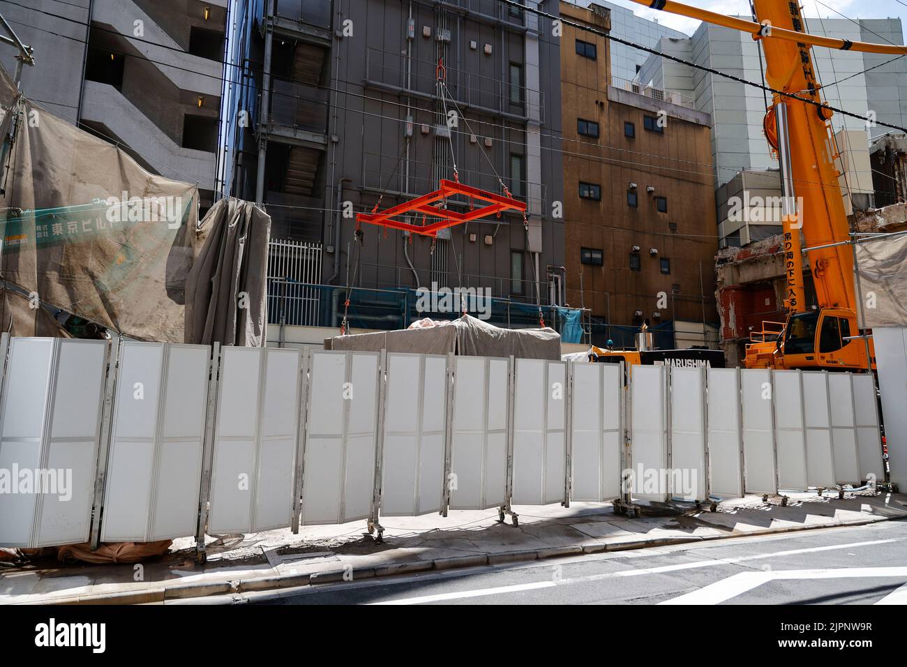 Tokio, Japan. 19. August 2022. Ein Kran trägt eine Kapsel während des Abrisses am Nakagin Capsule Tower in Ginza am 19. August 2022 in Tokio, Japan. Der Rückbau von 140 Einzelkapseln des futuristischen Gebäudes (Mischnutzung Wohn- und Büroturm) wird im Rahmen der Abbrucharbeiten bis Ende dieses Jahres fortgesetzt. Quelle: Rodrigo Reyes Marin/AFLO/Alamy Live News Stockfoto