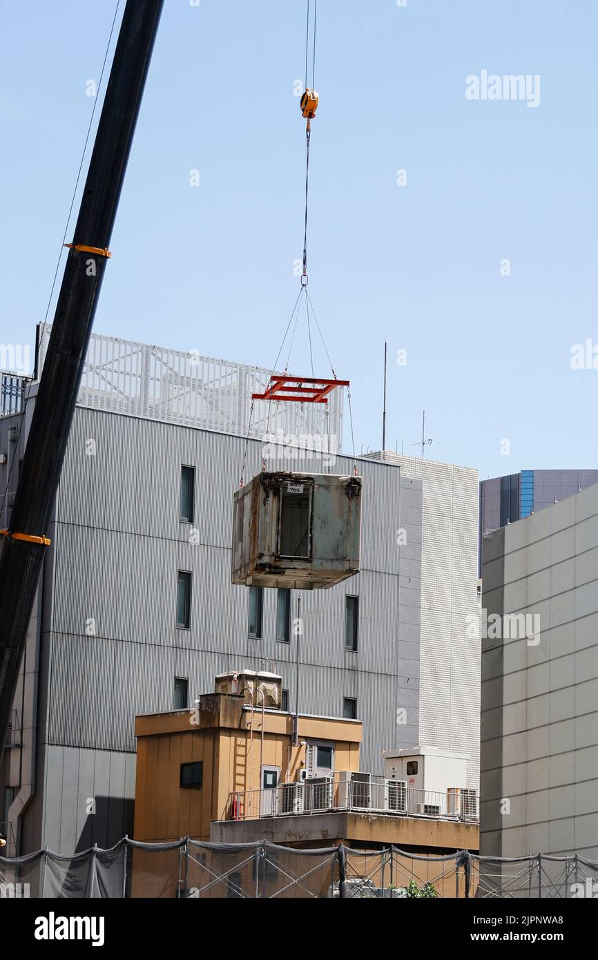 Tokio, Japan. 19. August 2022. Ein Kran trägt eine Kapsel während des Abrisses am Nakagin Capsule Tower in Ginza am 19. August 2022 in Tokio, Japan. Der Rückbau von 140 Einzelkapseln des futuristischen Gebäudes (Mischnutzung Wohn- und Büroturm) wird im Rahmen der Abbrucharbeiten bis Ende dieses Jahres fortgesetzt. Quelle: Rodrigo Reyes Marin/AFLO/Alamy Live News Stockfoto