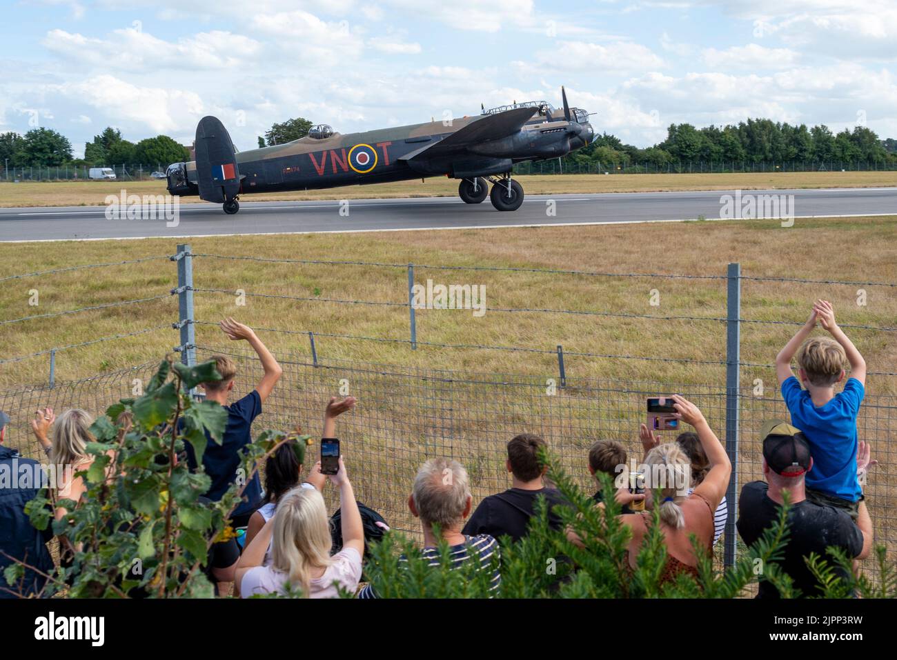 London Southend Airport, Essex, Großbritannien. 19. August 2022. Der Battle of Britain Memorial Flight (BBMF) der RAF, Lancaster, Spitfire und Hurrian nutzen den zivilen Flughafen für die Airshows dieses Wochenendes in Eastbourne und Folkestone. Viele Menschen sind hinausgekommen, um sie zu sehen und säumen die Zäune. Die Menschen begrüßen den Bomber RAF BBMF Avro Lancaster Stockfoto