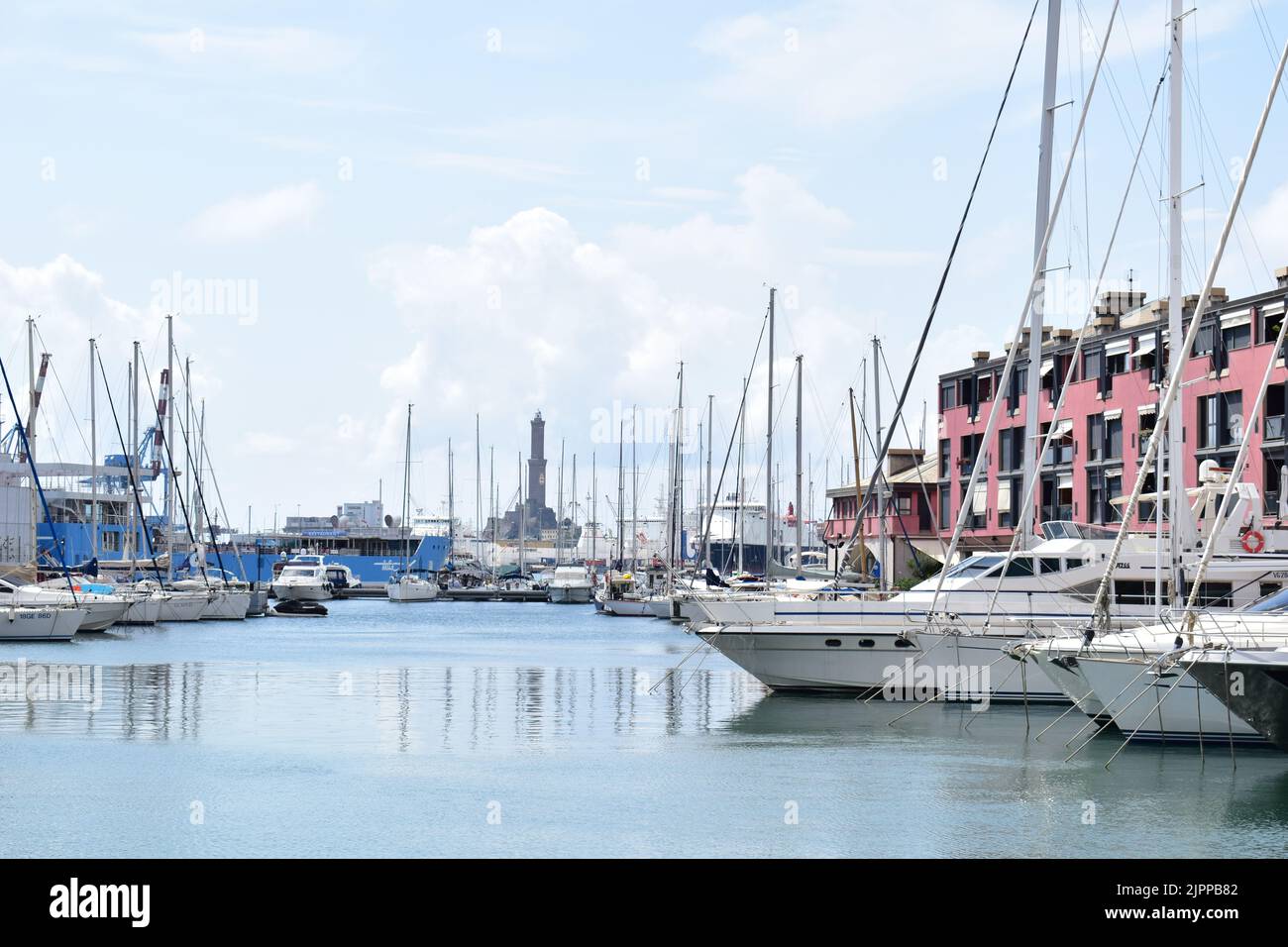 GENUA, ITALIEN - 15. AUGUST 2022: Yachten und Boote in der Hafenmarina in Genua. Der historische Leuchtturm im Hintergrund. Stockfoto