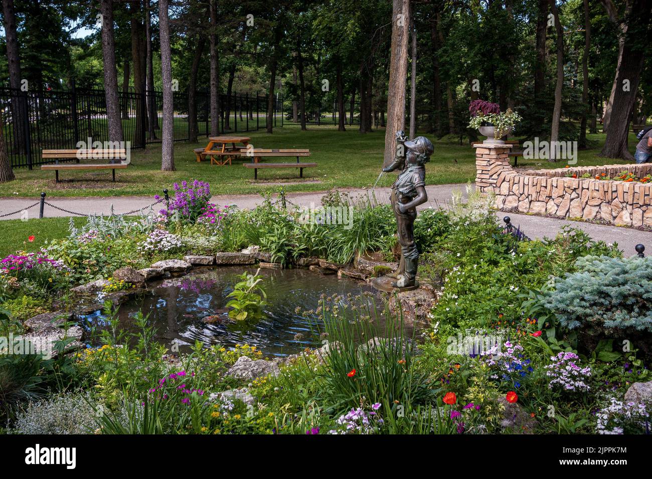 Ein Springbrunnen eines kleinen Jungen, der einen Stiefel im Assiniboine Park in Winnipeg hält Stockfoto