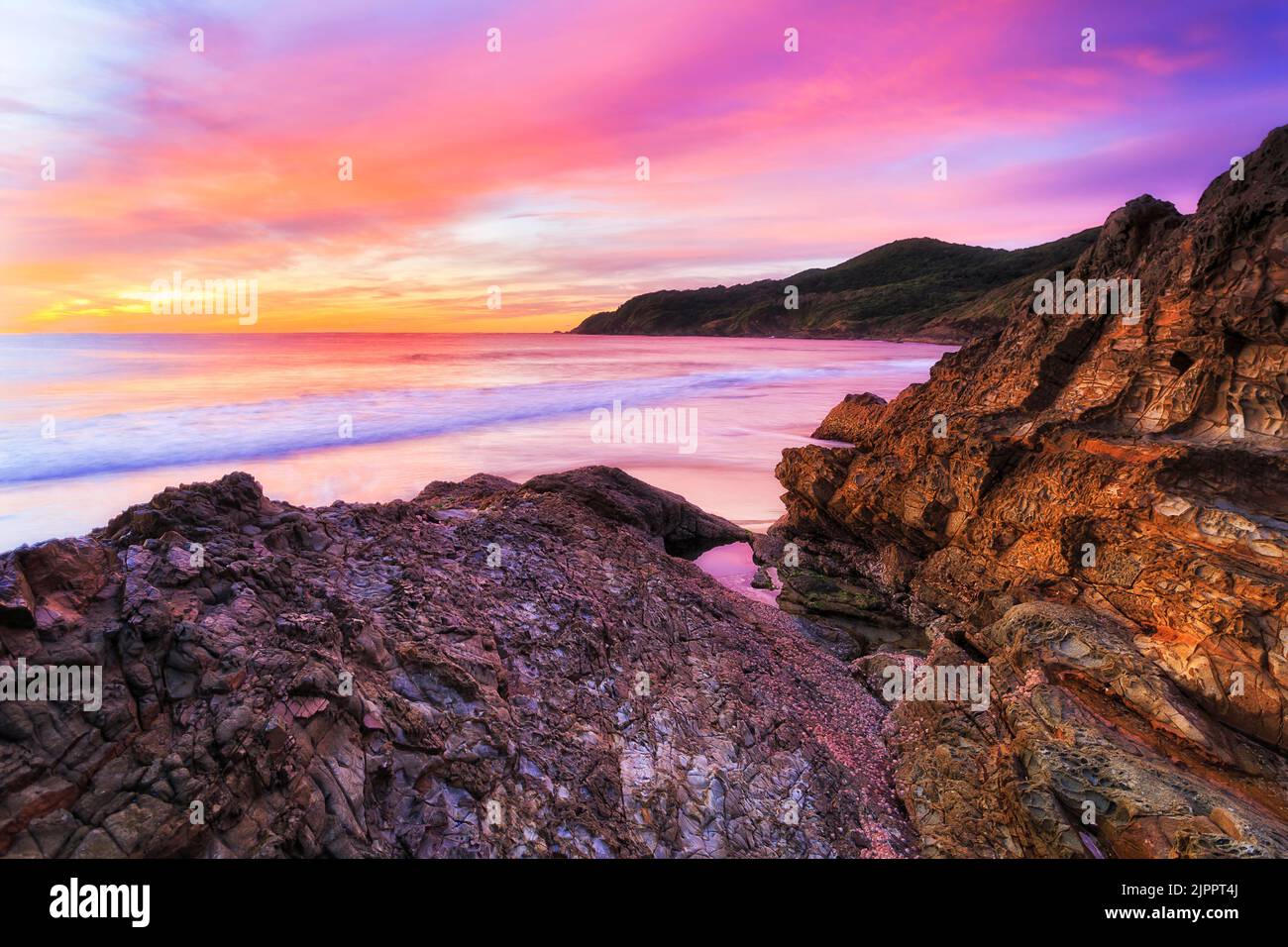 Rosafarbene farbenfrohe Sonnenuntergänge am Burgess Beach in Forster Town in Australien an der Pazifikküste. Stockfoto