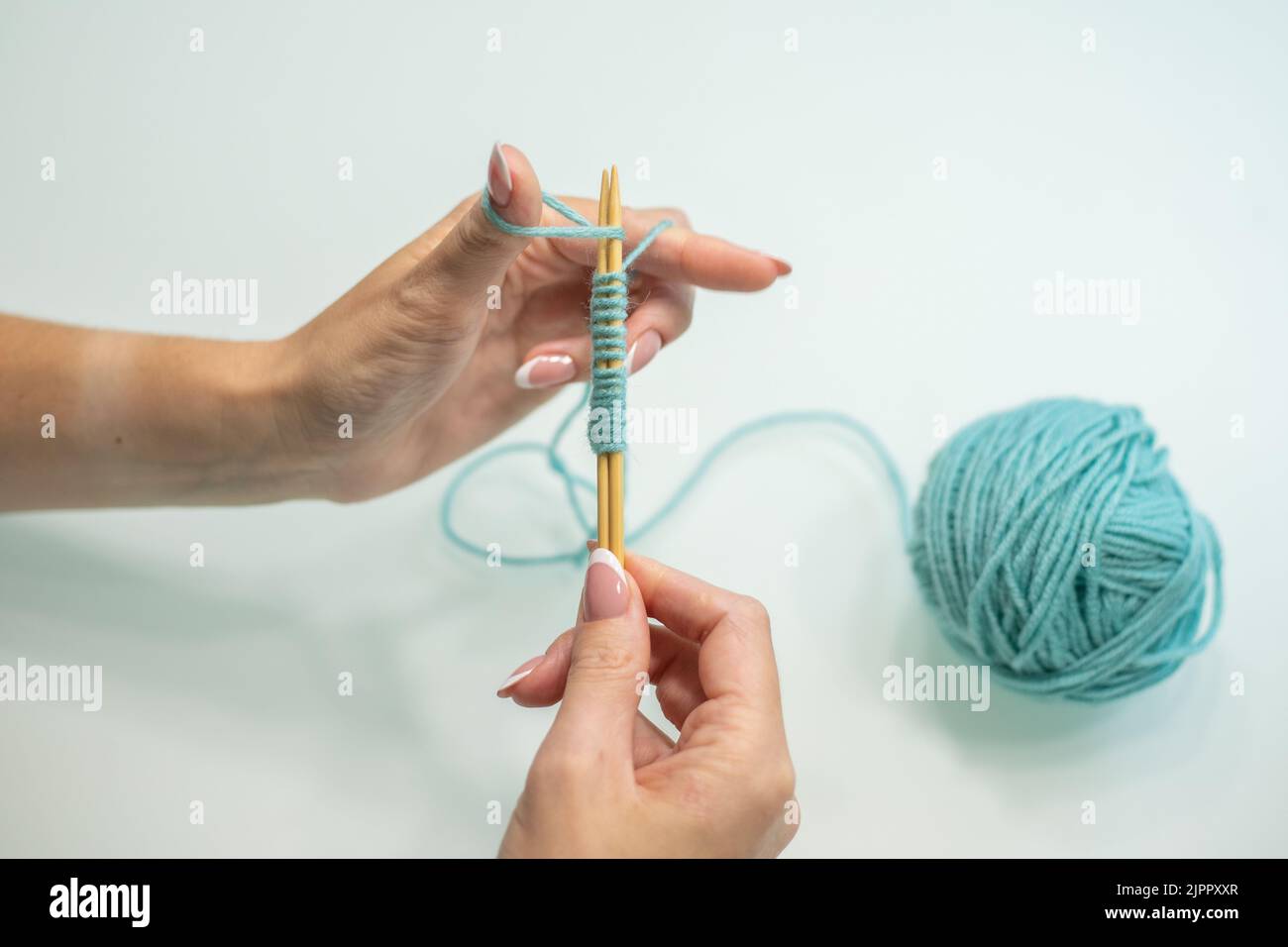 Set von Schlaufen auf den Nadeln Schritt für Schritt. Wolle und Baumwolle Stricken. Stockfoto
