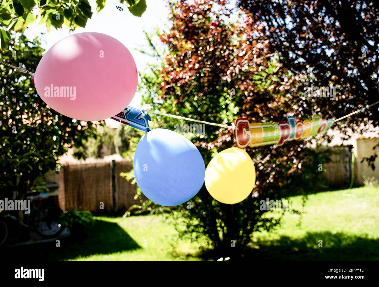 Feier einer Geburtstagsfeier für Kinder mit Ballons im Garten eines Hauses Stockfoto