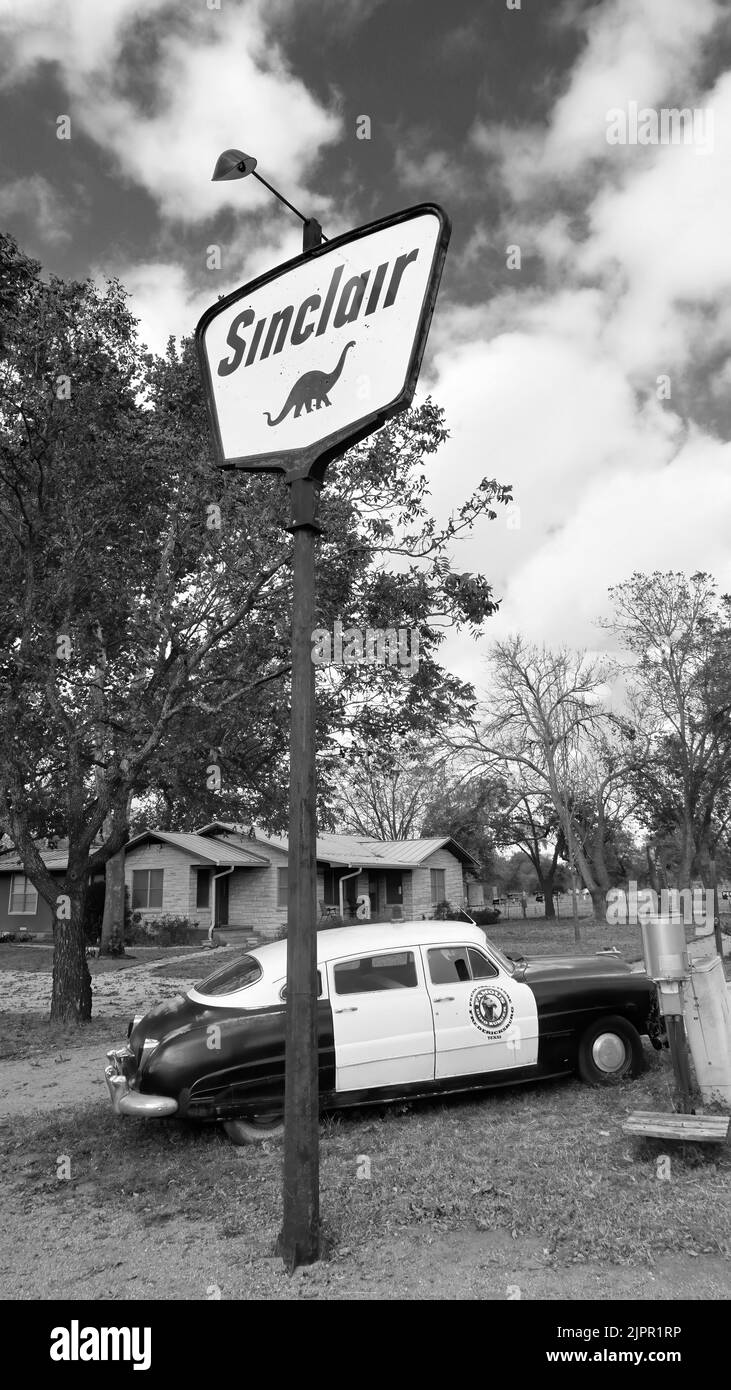 Fredericksburg, Texas - Nov. 12, 2020 Old Antique 1950 Hudson Police Car geparkt neben 1950s Sinclair Oil Corporation Gas-Schild. Stockfoto