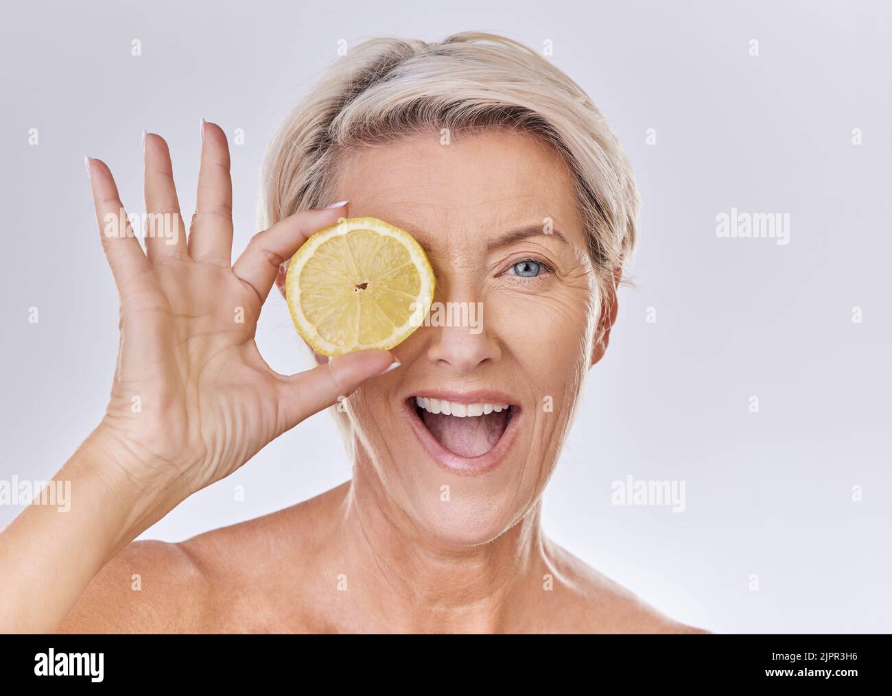 Hautpflege, Wellness und Gesicht der reifen Frau mit Falten halten Zitrone mit Ernährung, Vitaminen und Gesundheit. Porträt einer glücklichen älteren Dame mit Früchten Stockfoto