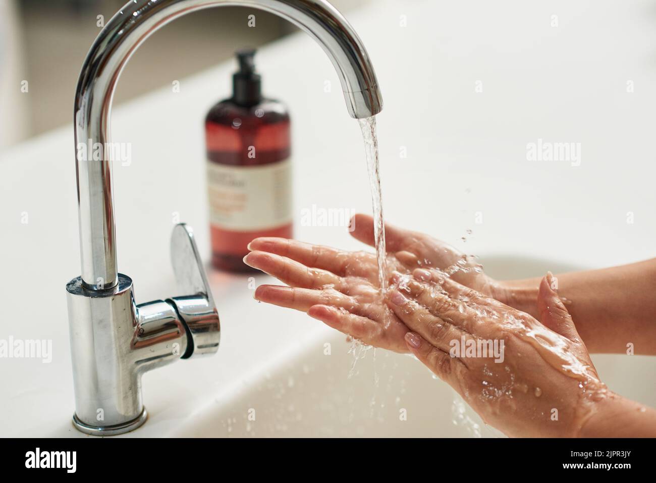 Waschen Sie immer Ihre Hände. Eine unkenntliche Frau, die ihre Hände unter fließendem Wasser wäscht. Stockfoto