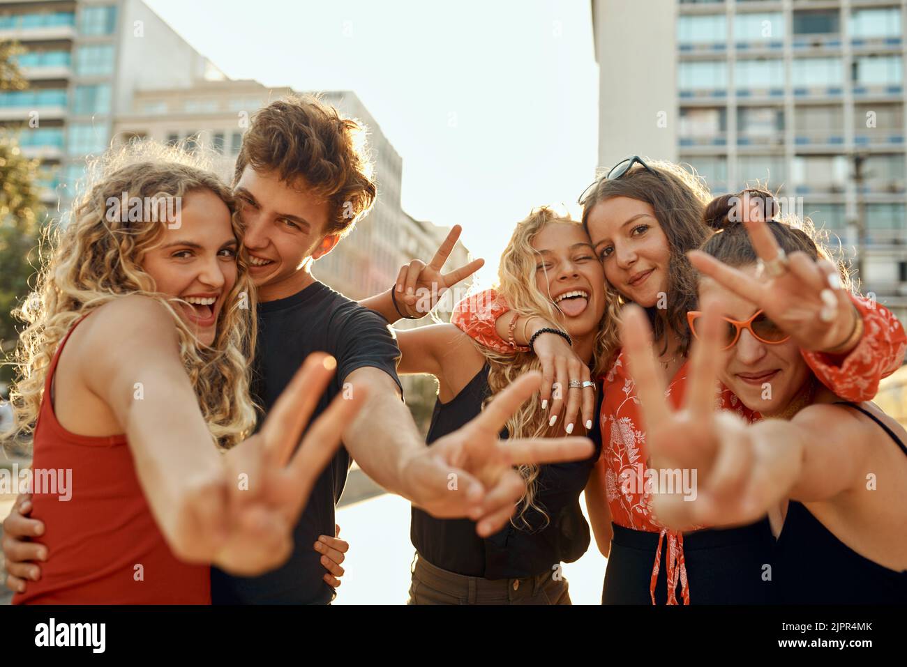 Frieden raus. Beschnittenes Porträt einer Gruppe junger Freunde, die während ihres Aufenthalts in der Stadt Friedensschilder aufblitzen. Stockfoto