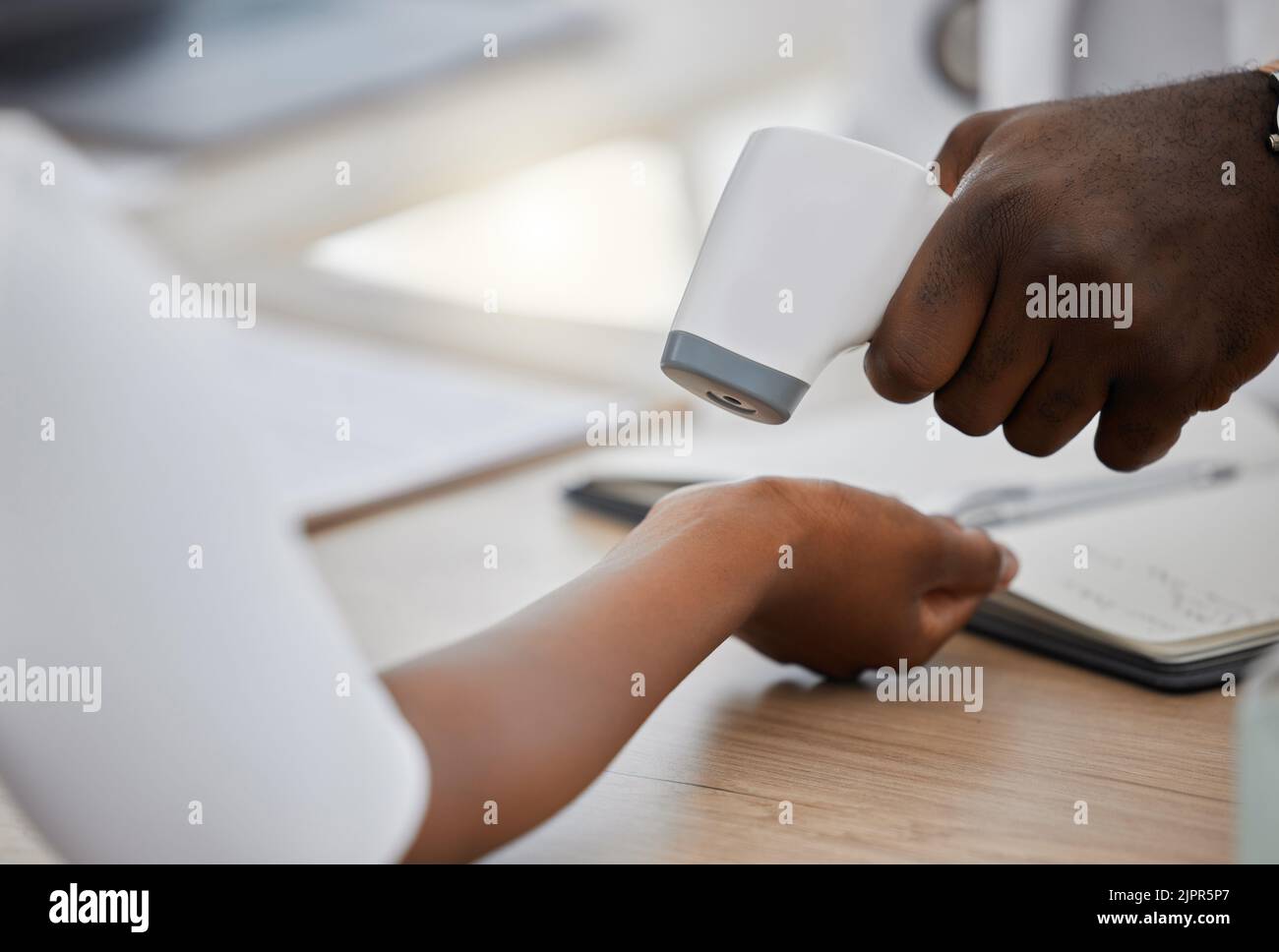 Der Arzt, der die Temperatur des Handgelenks eines kranken Patienten überprüft, hat den Patienten dazu gebracht, auf Fieber, Erkrankungsrisiko oder Grippe zu testen. Nahaufnahme beim Scannen von Händen mit einem Laserthermometer Stockfoto