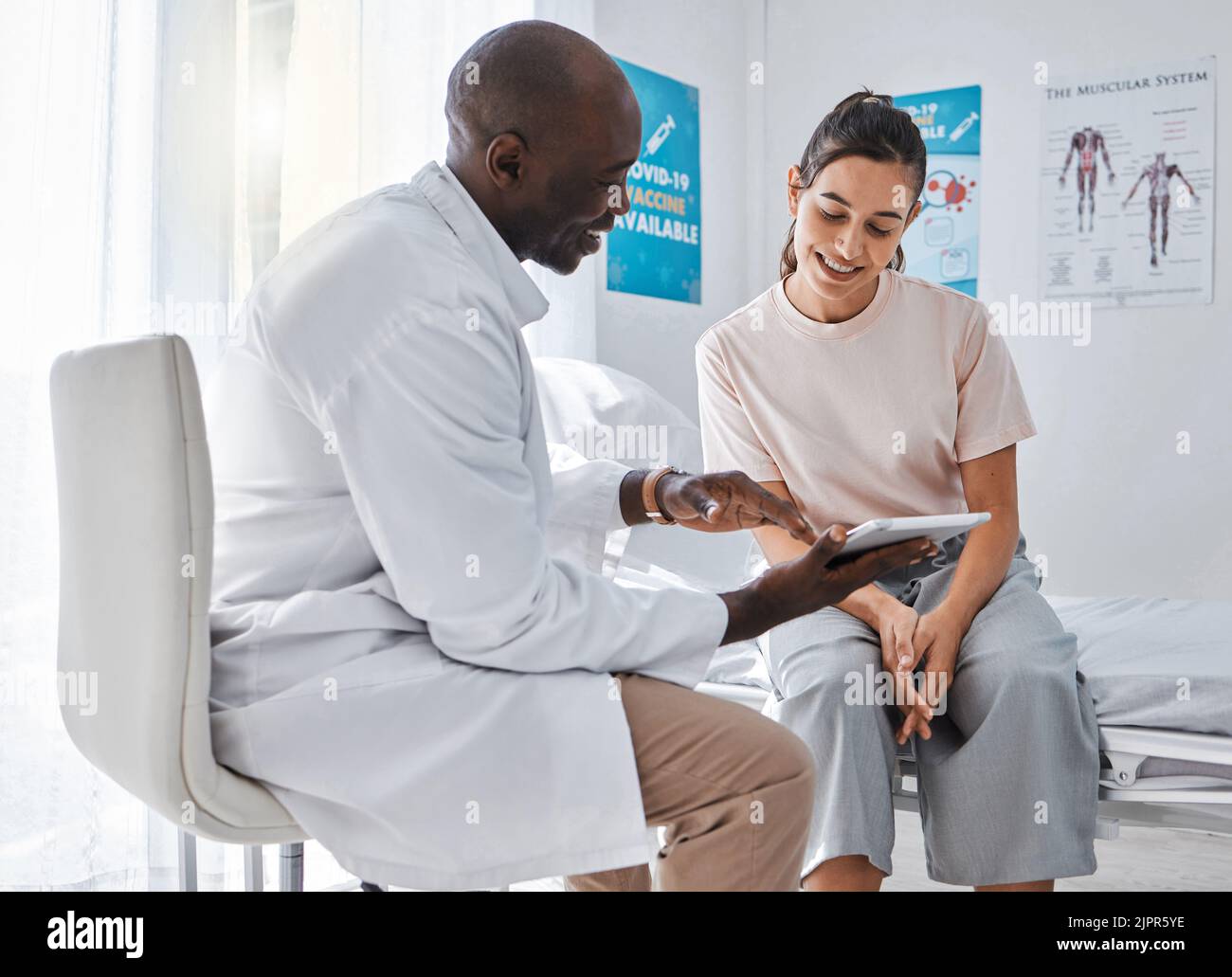 Arztbesuch oder Gesundheitsfachkraft, die eine Frau konsultiert und mit einer Tablette die Gesundheit erklärt. Ein Arzt oder Hausarzt im Gespräch mit einem Patienten und Stockfoto