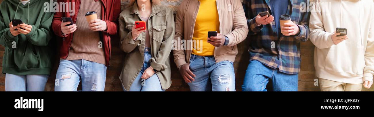 Multirassische Freunde nutzen Smartphones, um Inhalte in sozialen Netzwerken zu teilen. Technologie Lifestyle Konzept - selektiver Fokus Stockfoto
