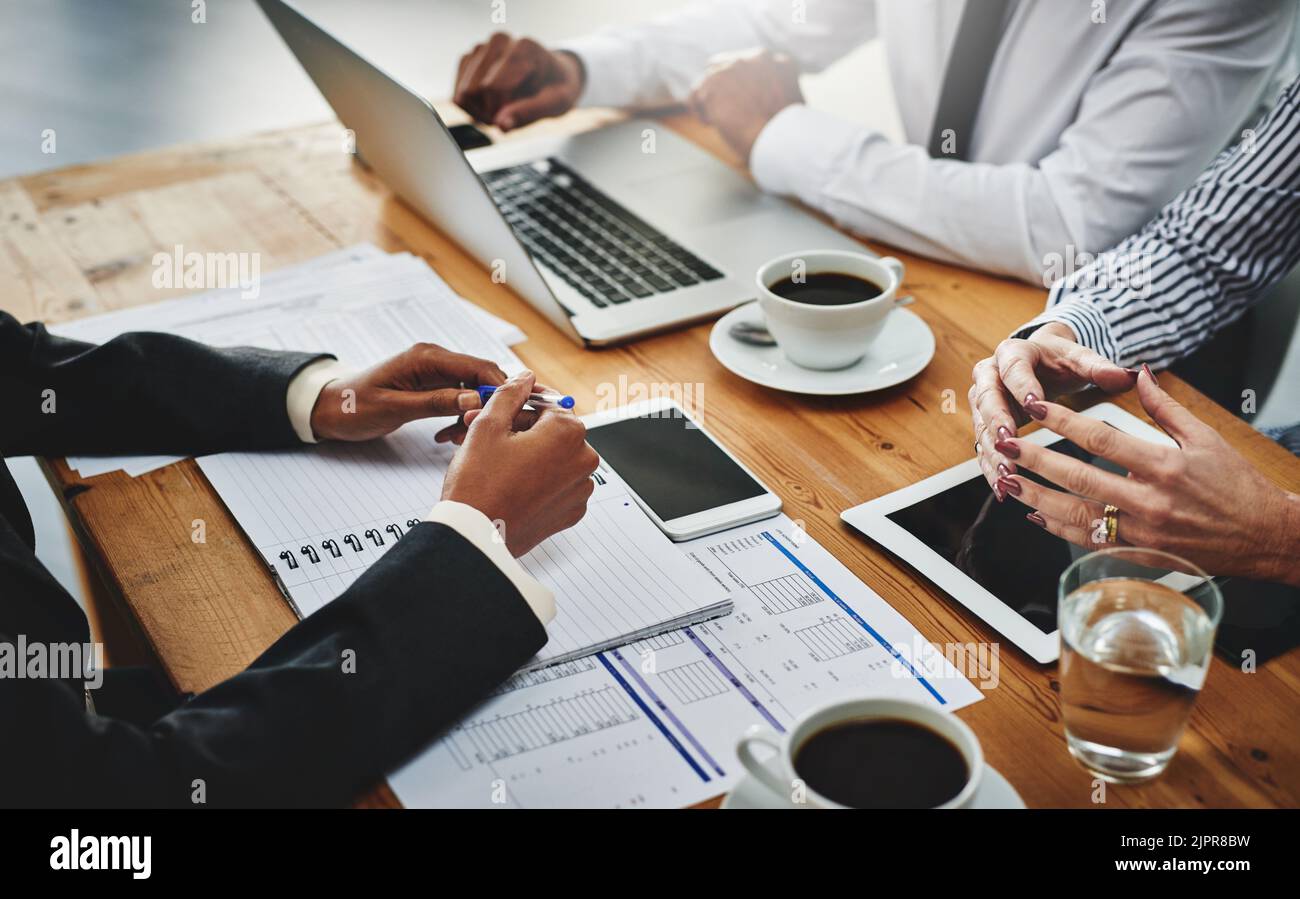 Hart arbeiten, um ihren langfristigen Erfolg zu sichern. Eine Gruppe von nicht erkennbaren Geschäftsleuten, die ein Treffen in einem Büro abhalten. Stockfoto