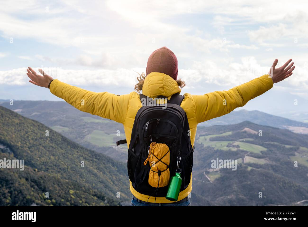 Wanderer mit erhobenen Armen auf dem Gipfel des Berges - Mann, der den Triumph genießt und feiert - Sport- und Erfolgskonzept Stockfoto