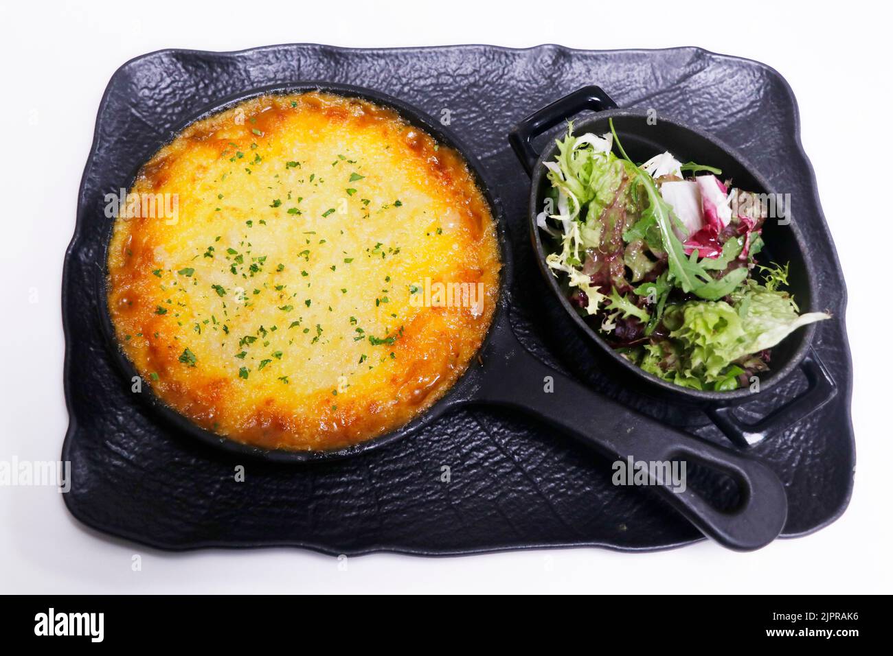 Traditioneller englischer Cottage Pie mit gemischtem Salat aus Blättern Stockfoto