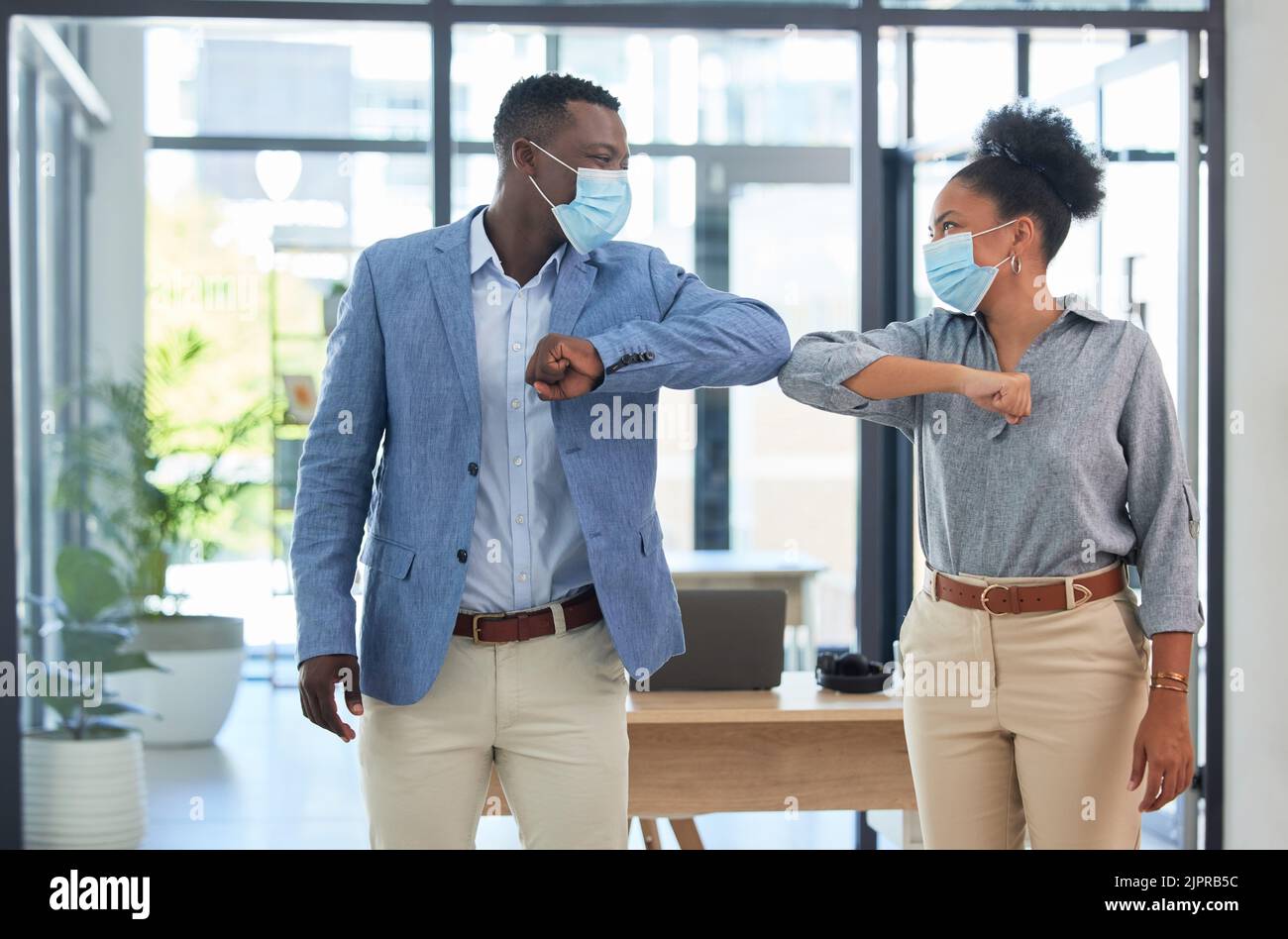 Covid-Vorschriften, Ellenbogenanstoß und soziale Distanz im Büro mit Maske. Unternehmensarbeit während der Sperre, junge Startup-Manager interviewt neu Stockfoto