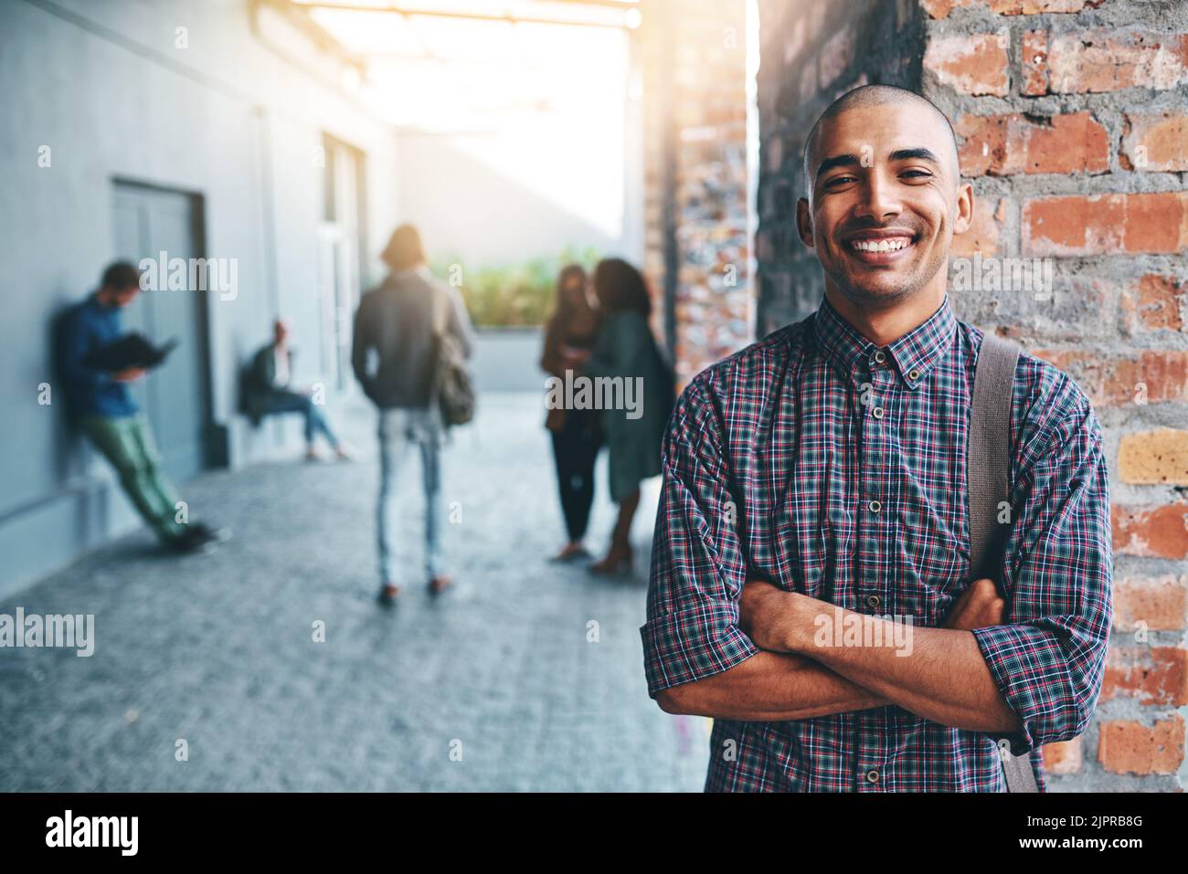 Bereit, meiner Zukunft zu begegnen. Porträt eines glücklichen jungen Mannes, der draußen auf dem Campus steht. Stockfoto